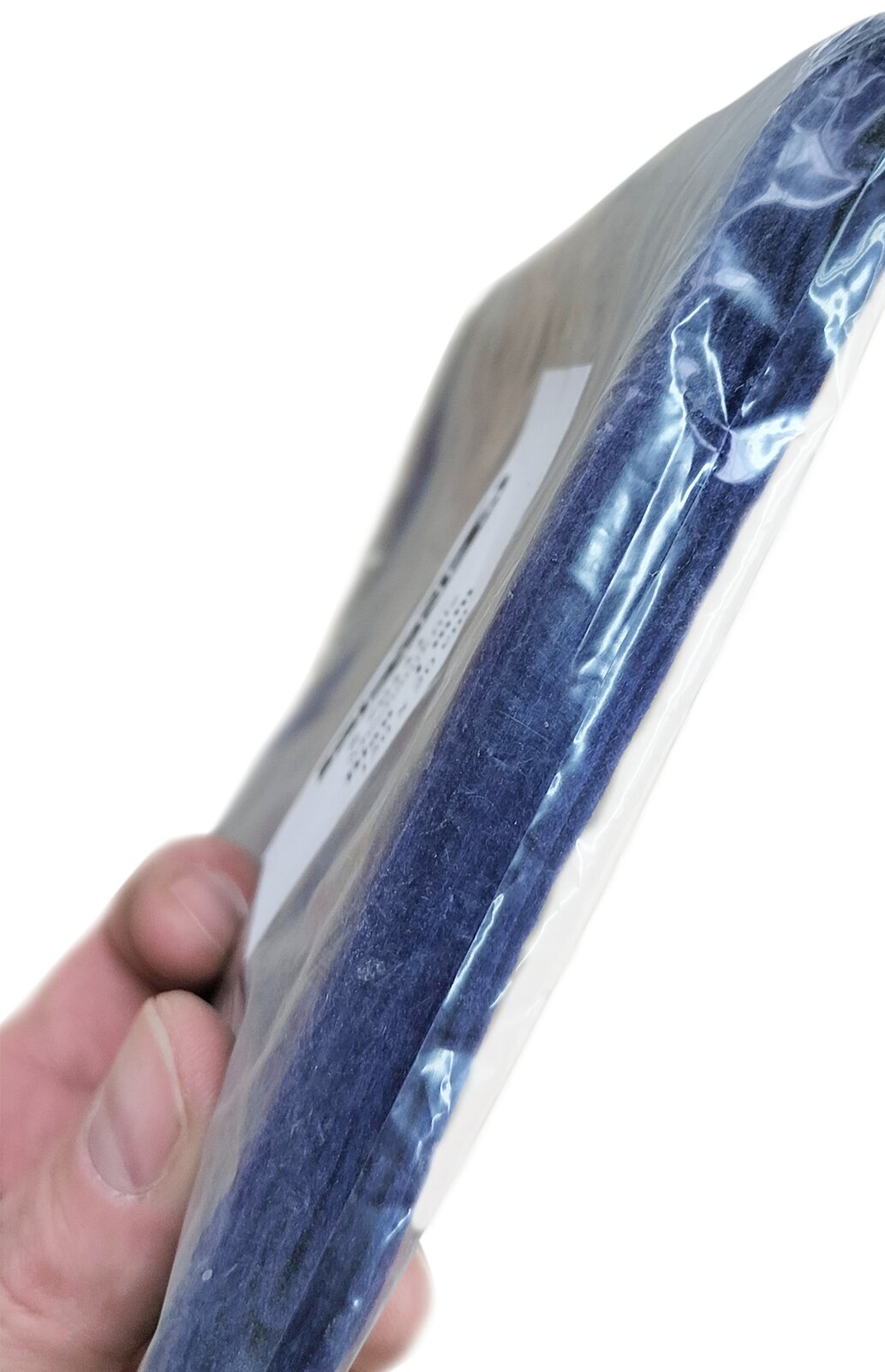 Zdjęcie przedstawia filc bity. Widoczne są płaty filcu w kolorze granatowym, w ujęciu z boku, w przeźroczystym foliowym opakowaniu.