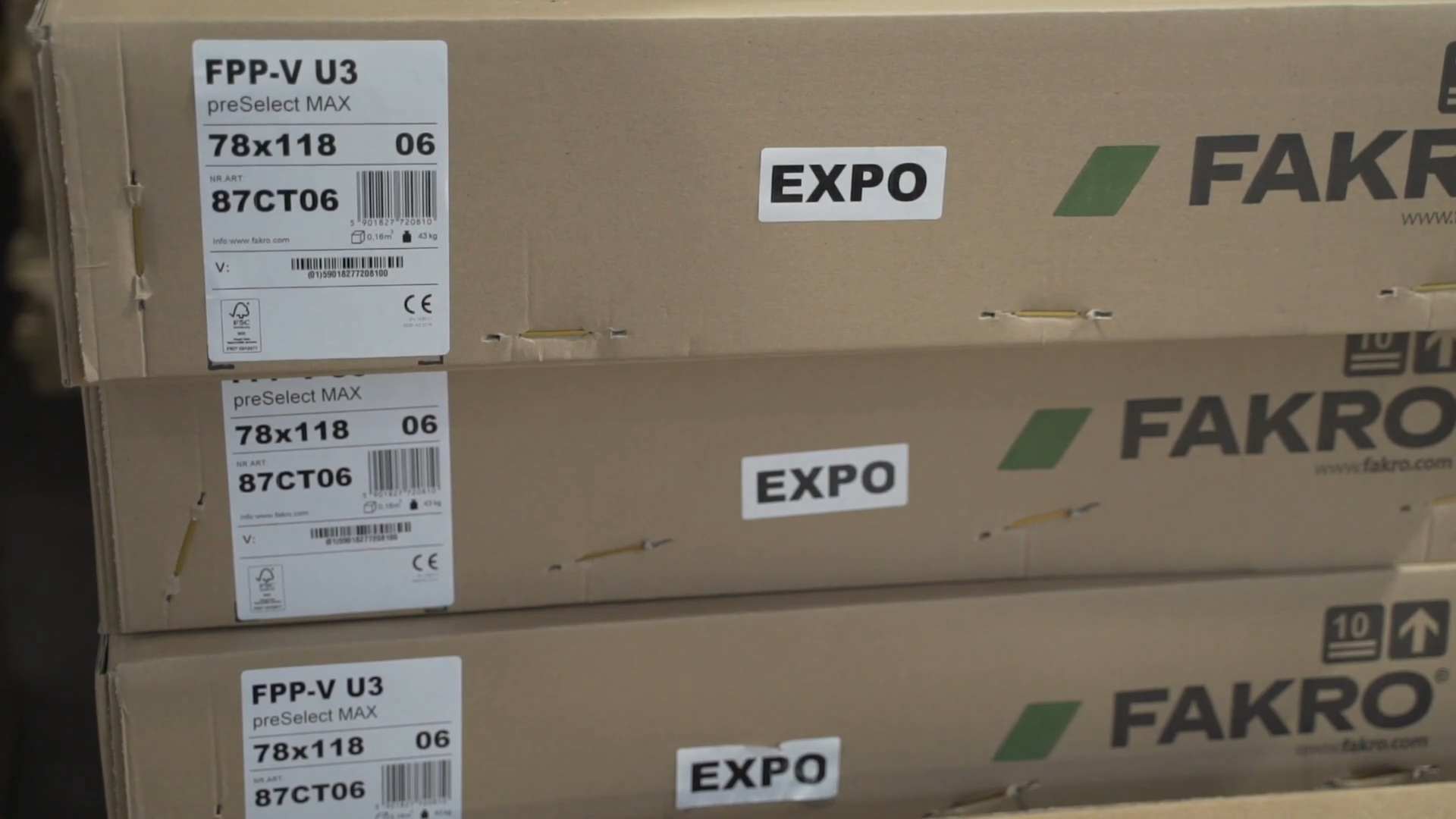 Grafika opakowania kartonowe, na które zostały nalepione znaki informacyjne.