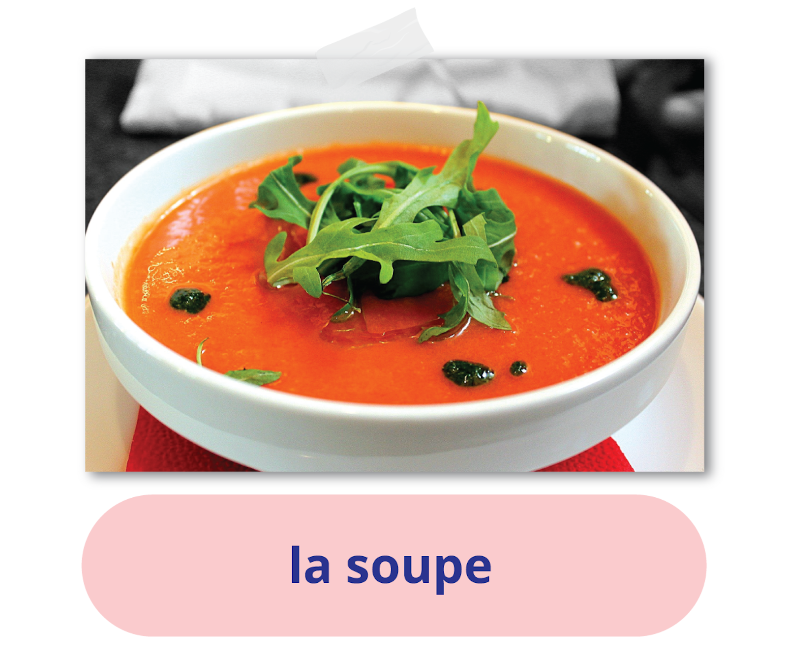 Ilustracja przedstawia miseczkę z zupą pomidorową - podpis: la soupe.