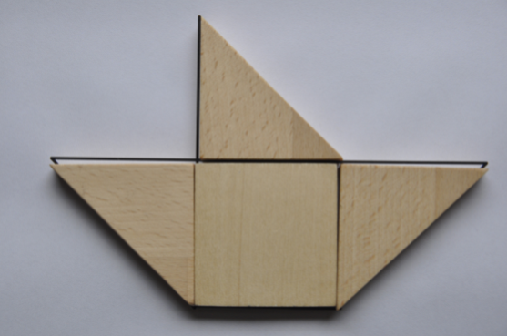 Przykład wykorzystania drewnianych, magnetycznych figur geometrycznych do wypełnienia konturu przedstawiającego żaglówkę