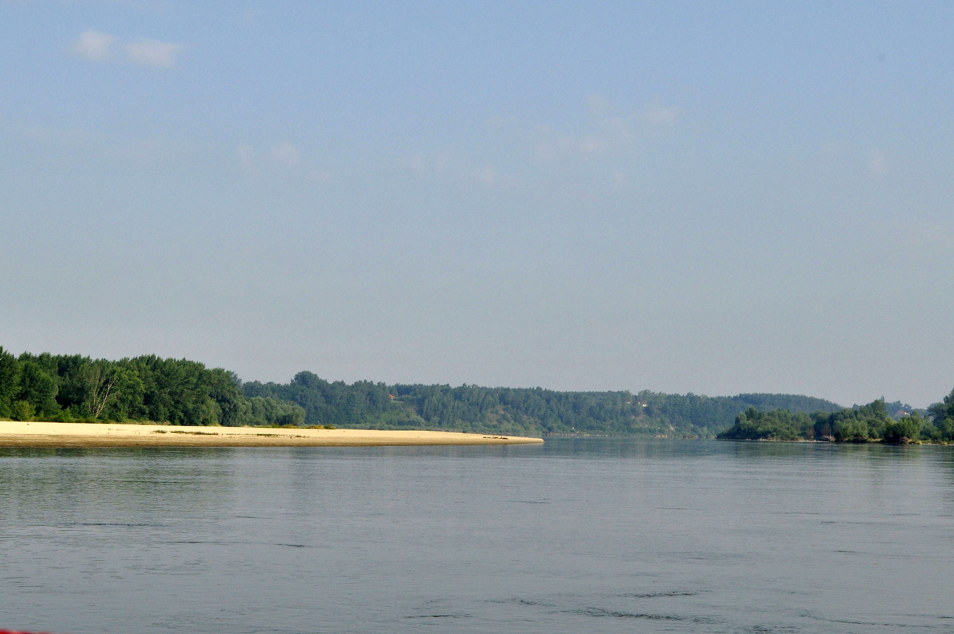Fotografia prezentuje szeroką dolinę Wisły w Gostyńsko-Wrocławskim Parku Krajobrazowym. Z lewej strony fragment piaszczystego brzegu. 
