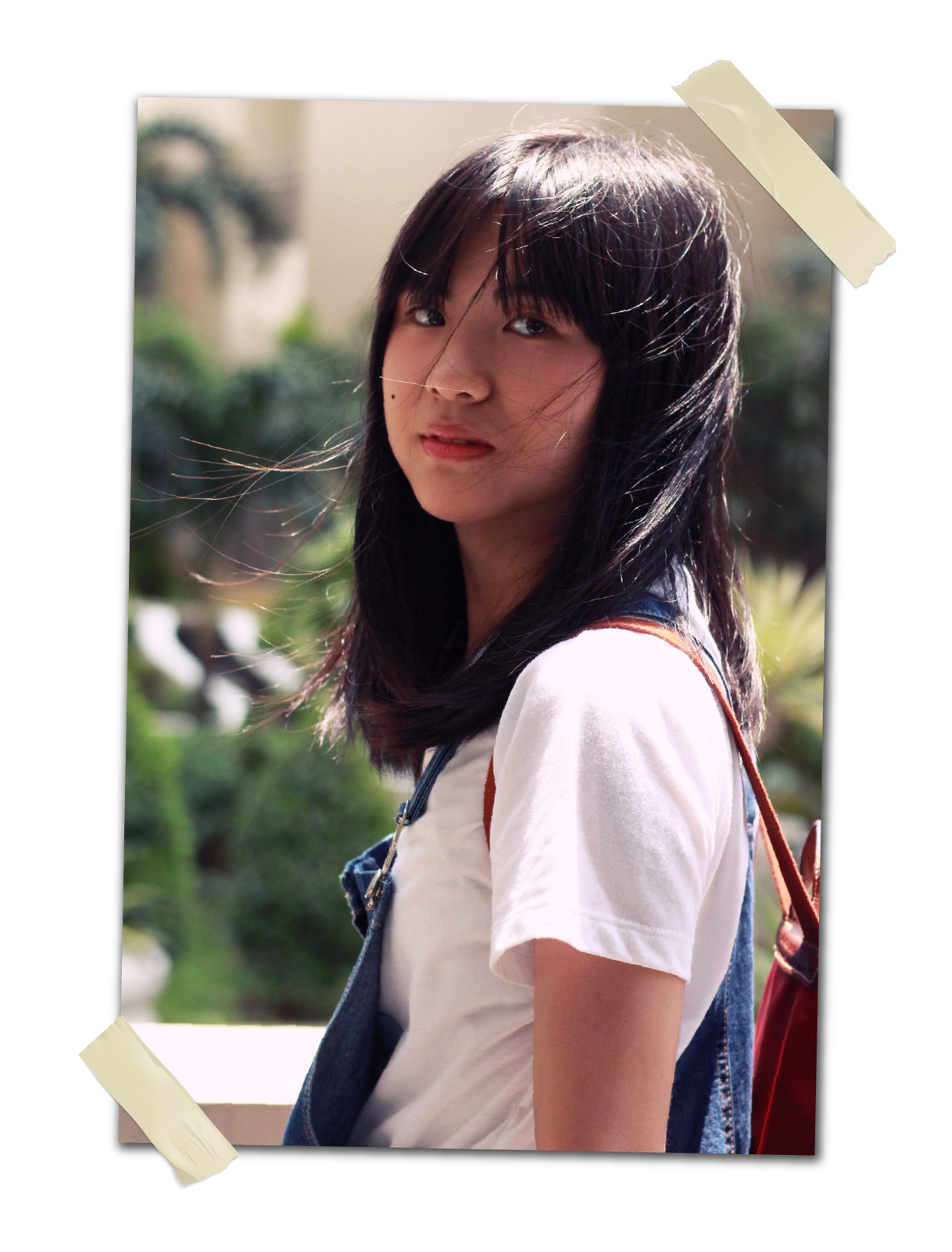 Zdjęcie przedstawia szczupłą nastolatkę o czarnych prostych i dość długich włosach. Ma czarne oczy i widoczny pieprzyk na policzku. 