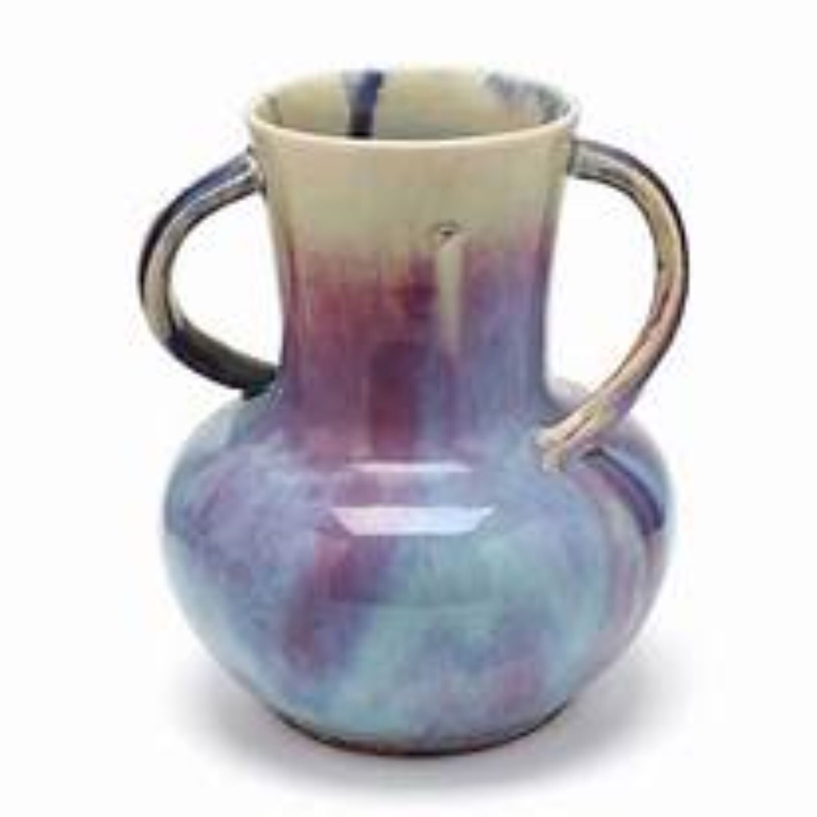 Fotografia przedstawia wazon szkliwiony z dwoma uchami. Ma pękaty spód, który zwęża się ku górze. Do zwężającej się szyjki przyczepiono dwa ucha. Wazon u góry jest mlecznobiały u dołu niebiesko‑fioletowy. Kolory układają się smugami od dołu do góry.