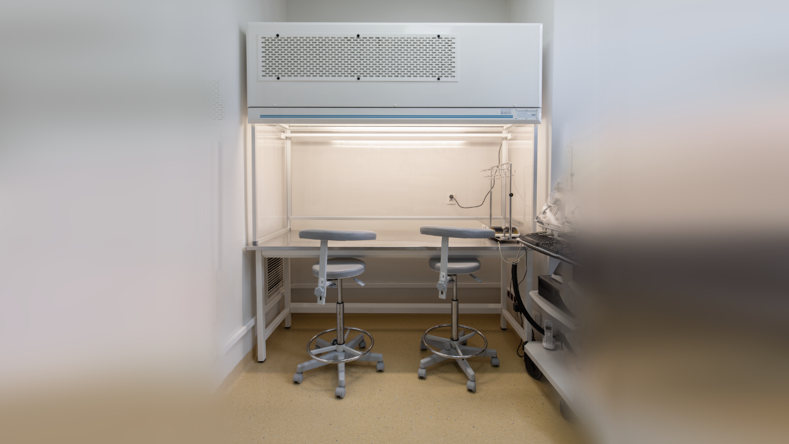 Zdjęcie przedstawia lożę z nawiewem laminarnego powietrza. Nad blatem umieszczone są lampy UV.