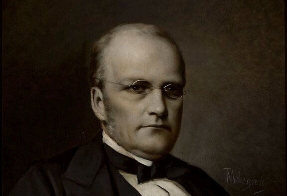 Na ilustracji portret Stanisława Moniuszki. Kompozytor przedstawiony jest jako potężny mężczyzna, z siwiejącymi włosami i bokobrodami. Ubrany jest w koszulę, kamizelkę i marynarkę. Na szyi ma muchę, na nosie okulary w metalowych oprawkach.