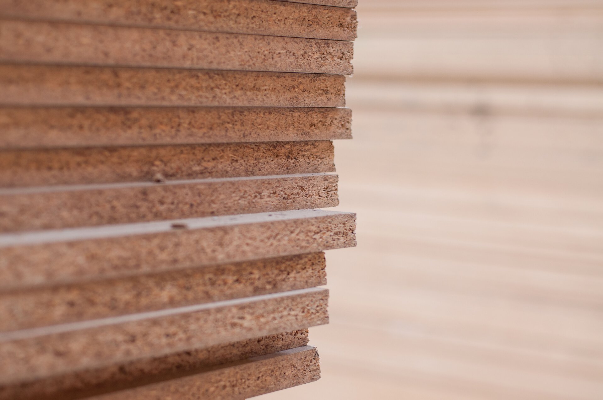 Zdjęcie przedstawia zbliżenie na kilkanaście płyt pilśniowych ustawionych jedna na drugiej.