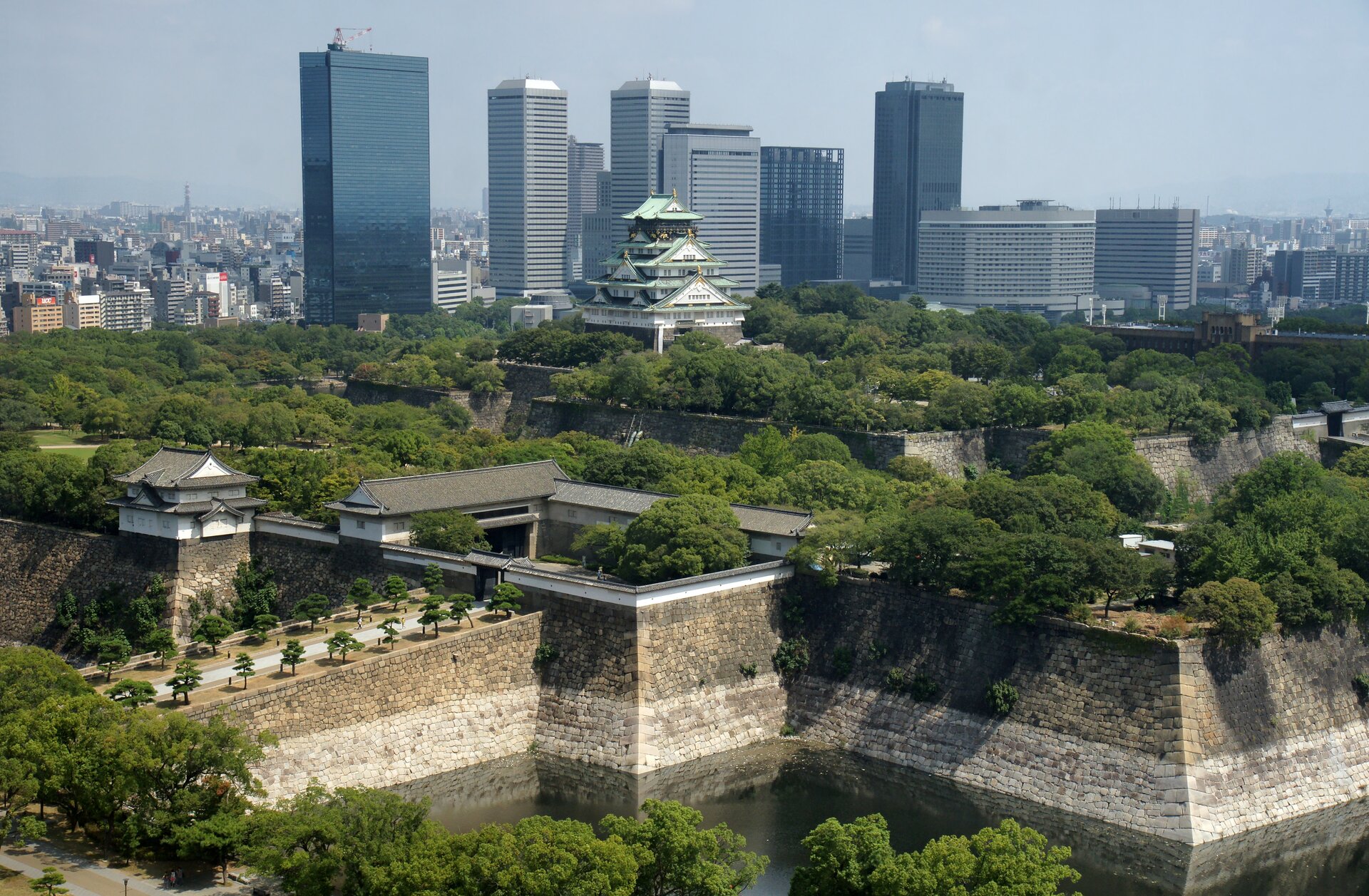 Na zdjęciu nowoczesne zabudowania biznesowe na tle charakterystycznej japońskiej świątyni z przyległymi do niej rozległymi ogrodami.