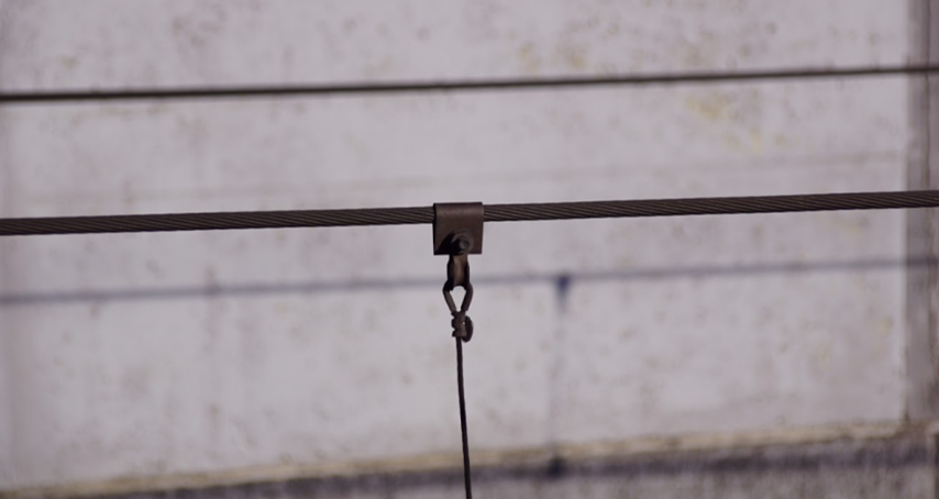 Ilustracja przedstawia metalową linę nośną. 