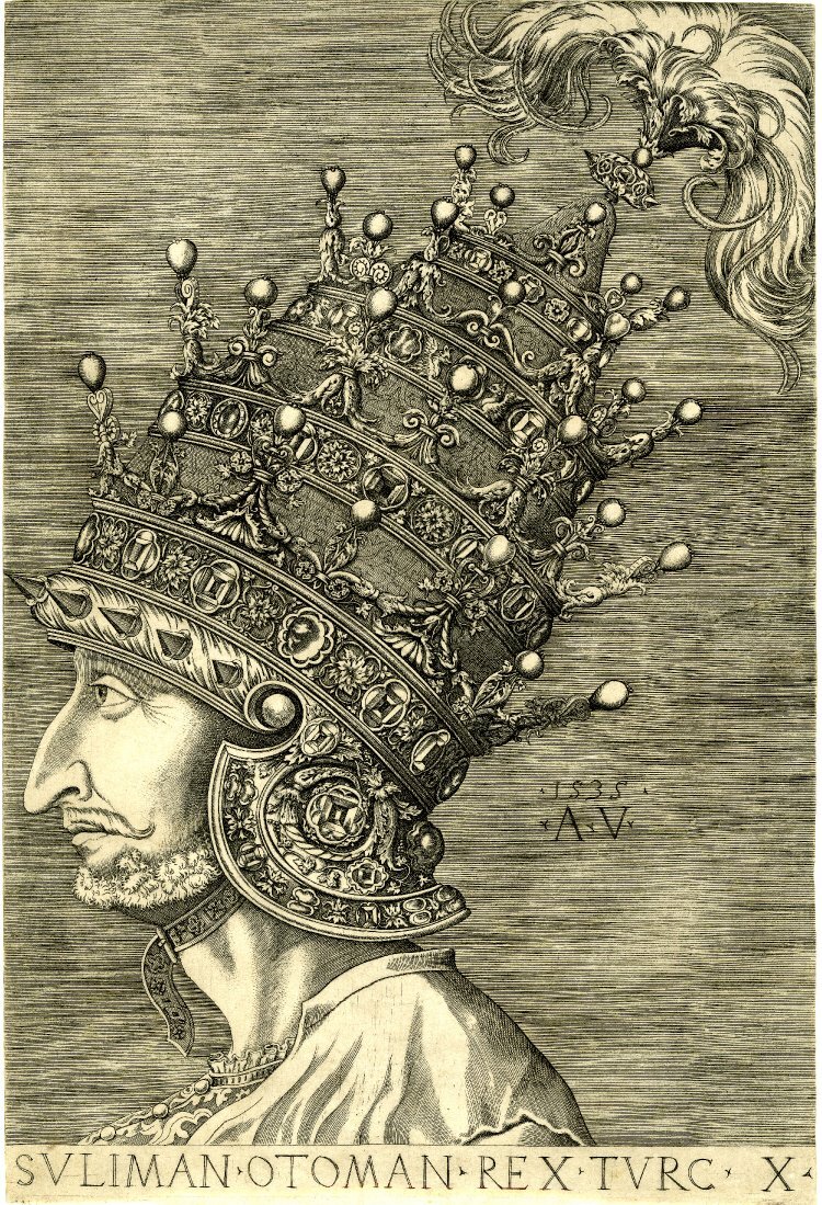 Kliknij, aby powiększyć Czarno‑biała grafika przedstawia lewy profil Sulejmana Wspaniałego. Ma wąski pociągły i garbaty nos. Na głowie ma bardzo wysoką koronę w kształcie stożka. Korona jest bogato zdobiona i zakończona piórkami.