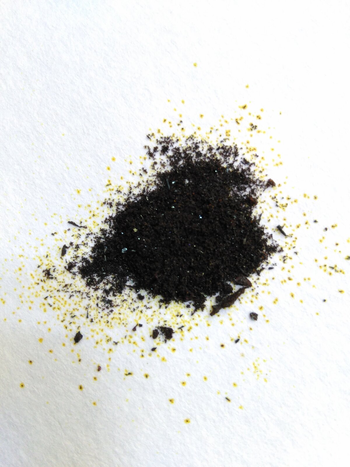 Na zdjęciu jest pewna ilość chlorku żelaza. Ma postać czarnych, drobnych, sypkich wiórów. Gdzieniegdzie ich zabarwienie jest żółte.  