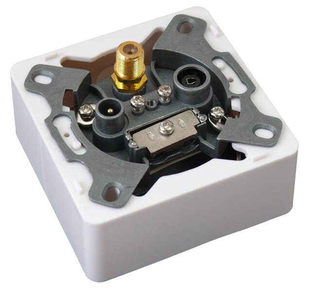 Grafika przedstawia wnętrze gniazda przelotowego RTV‑SAT. Jest to metalowa puszka, w której znajdują się trzy wyjścia: R, TV i SAT. Strzałki wskazują kierunek wejścia i wyjścia przewodu koncentrycznego. Gniazdo jest przytwierdzone do obudowy czterema śrubkami. 