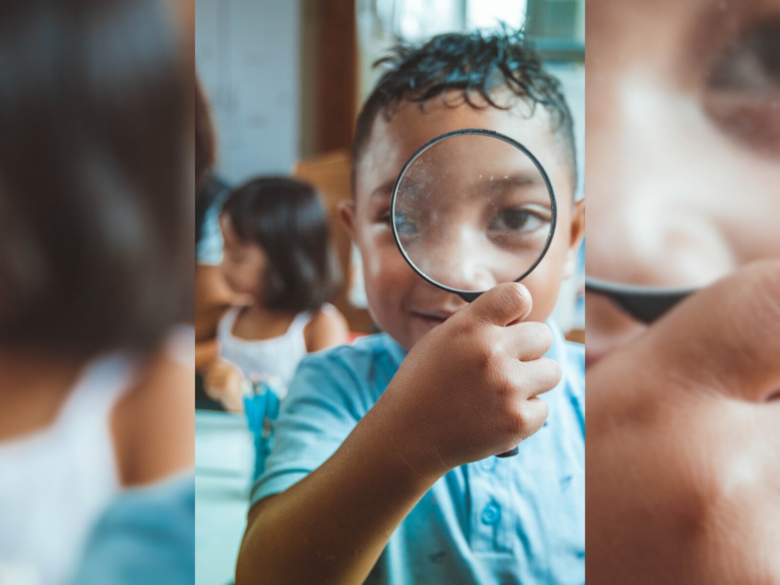 Zdjęcie przedstawia małego chłopca. Na wysokości twarzy chłopiec trzyma w ręku lupę.