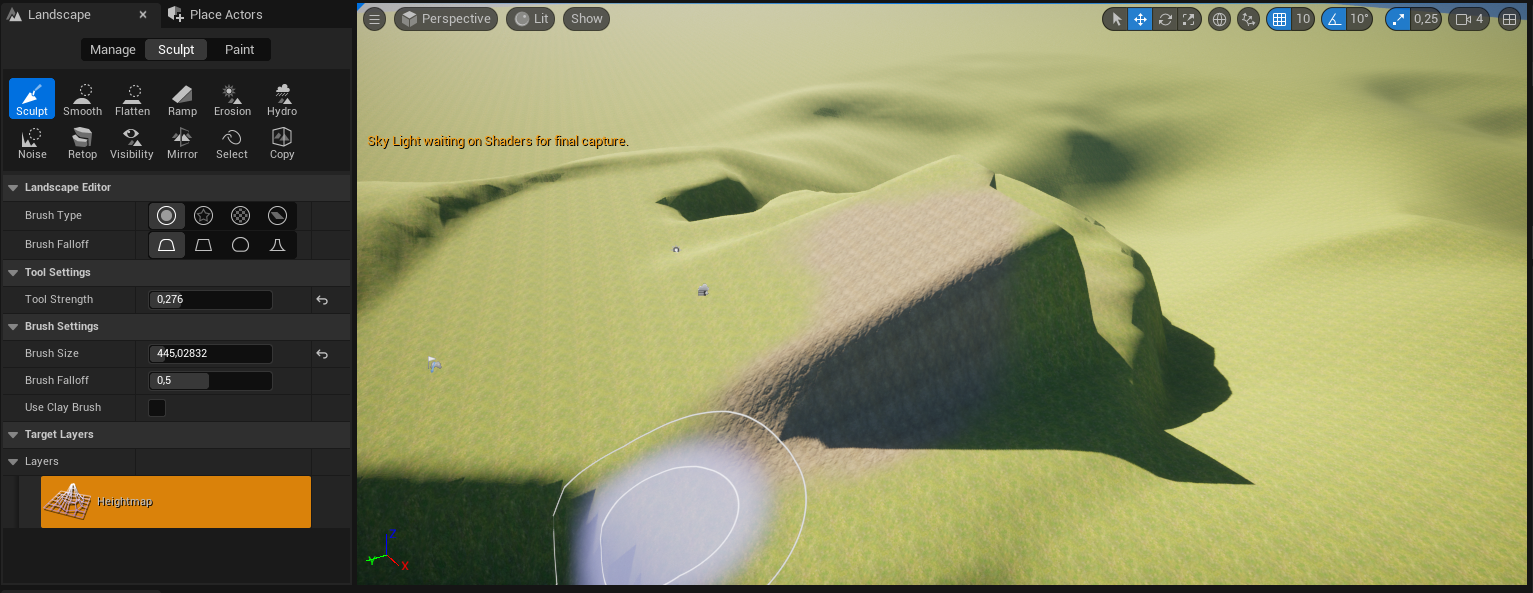 Ilustracja przedstawia zrzut ekranu - panel programu  Unreal Engine . Widoczny jest ekran z rozległą płaszczyzną w kolorze zielono - beżowym. Po prawej stronie znajduje się płaska powierzchnia, a w środku ekranu rampa przypominająca odwróconą figurę przestrzenną z dwoma bokami w kształcie trójkątów prostokątnych. Niżej położona płaszczyzna jest mocno pofalowana. Bliżej dolnej krawędzi po lewej stronie jest nieregularna, szara plama, wewnątrz i na zewnątrz obwiedziona szarym konturem. W lewym górnym rogu widać napis:  Sky Light waiting on Shaders for final capture . Na górze ilustracji znajdują się ułożone w rzędzie symbole graficzne, a lewej strony lista menu z dwoma zakładkami:  Landscape  i  Place Actors , trzy opcje z wybraną opcją środkową:  Manage, Sculpt, Paint , a pod spodem dwa szeregi ikonek z podpisami. Wybrana jest pierwsza ikonka w górnym rzędzie z symbolem dłuta i podpisem  Sculpt . Poniżej, w kolejnych linijkach znajdują się grupy opcji menu: pierwsza z nich to  Landscape Editor  z opcjami:  Brush Type:  - wybrana jest tu ikonka koła obwiedzionego okręgiem większej średnicy oraz  Brush Falloff  z wybraną ikonką przypominającą trapez z zaokrąglonymi górnymi rogami; druga z nich to:  Tool Settings  z opcją:  Tool Strength:  i wpisaną wartością 0,276; trzecia grupa opcji menu to:  Brush Settings  z opcją:  Brush Size  i wpisaną wartością 445,02832,  Brush Falloff  i wpisaną wartością 0,5 i odznaczoną opcją:  Use Clay Brush ; czwarta grupa opcji menu to:  Target Layers , a piąta  Layers  z pomarańczowym przyciskiem z ikonką siatki terenu z widocznym wybrzuszeniem oraz napisem:  Heightmap .