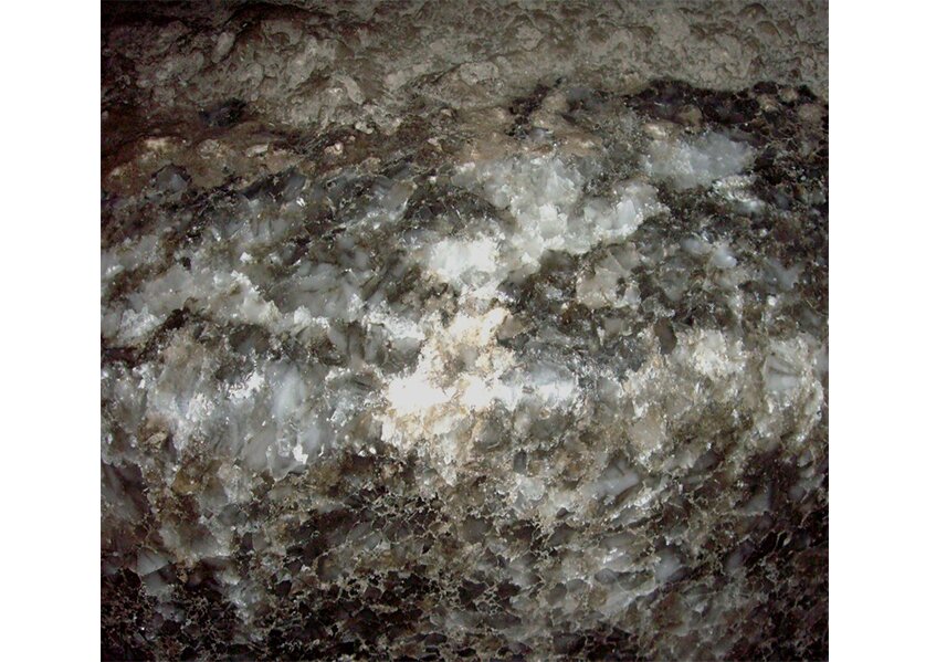 Zdjęcie przedstawia minerał sól kamienną. Sól jest skałą osadową. Na zdjęciu ściana w jaskini pokryta kryształami soli