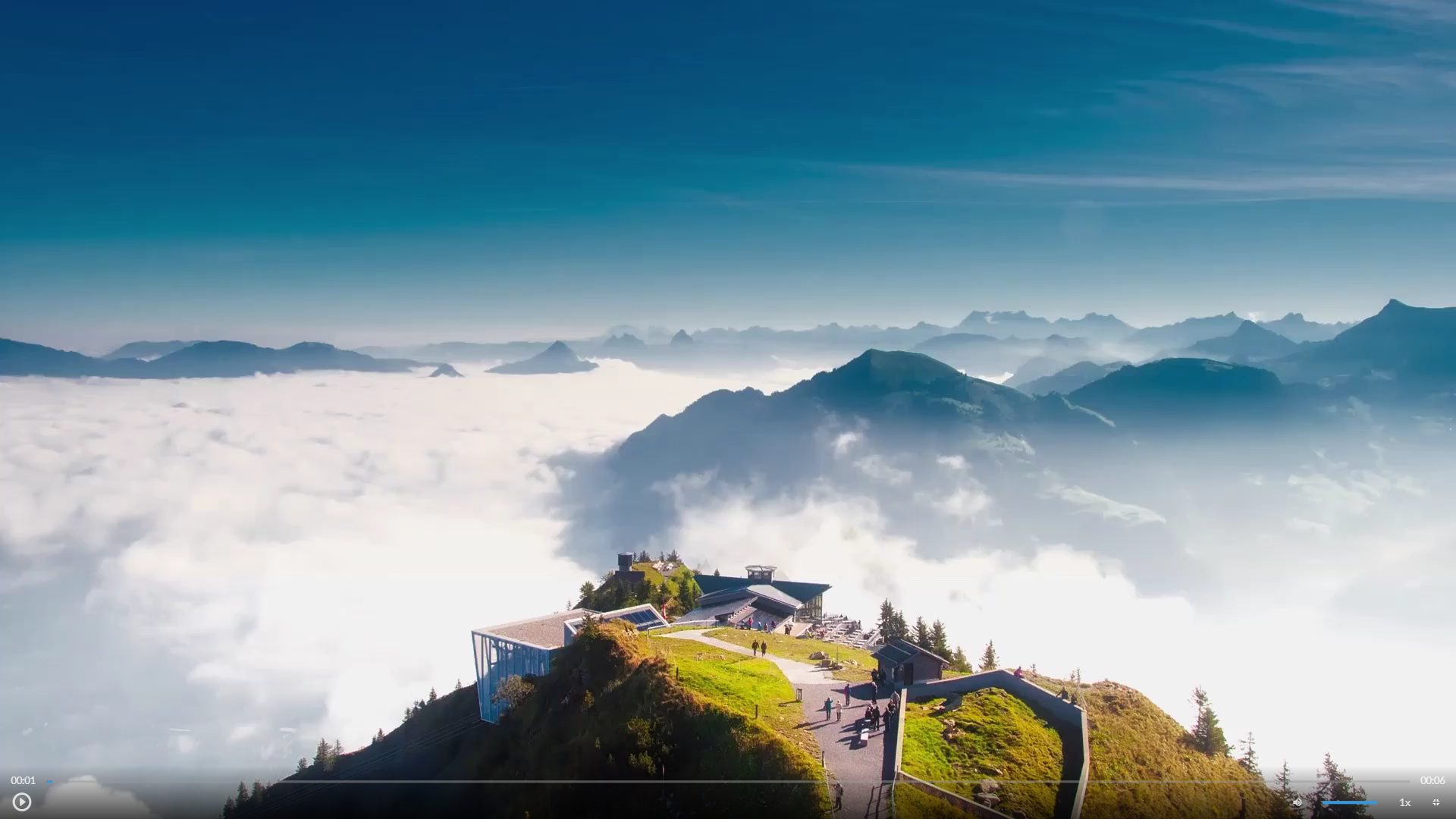 Scena przedstawia widok szczytów górskich. Na jednym z nich znajdują się atrakcje turystyczne.