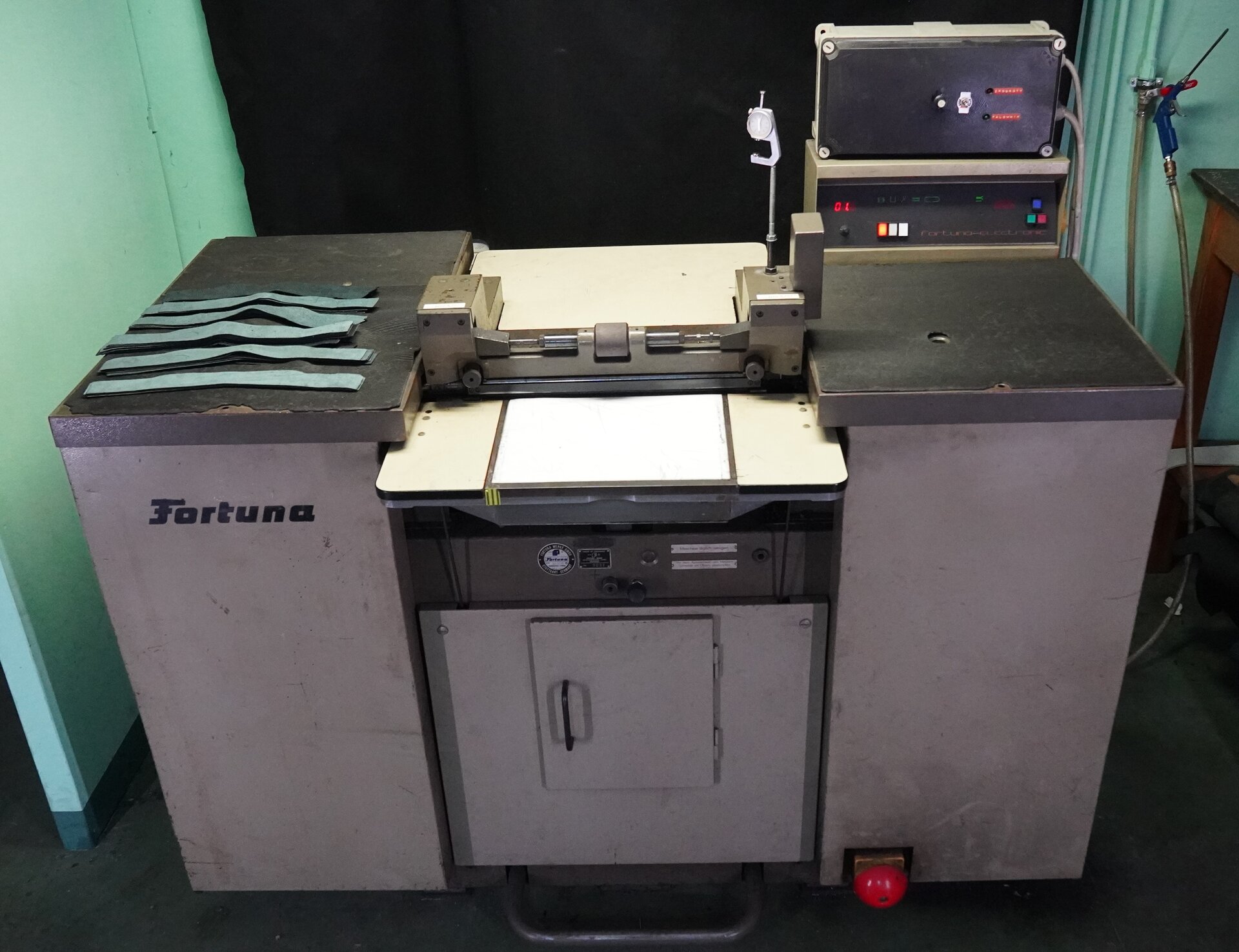 Zdjęcie przedstawia dużą wolnostojącą maszynę. Składa się ona z trzech segmentów. Po prawej stronie na górze stoi skrzynka z umieszczonymi na niej przyciskami. Nagranie tożsame z treścią.