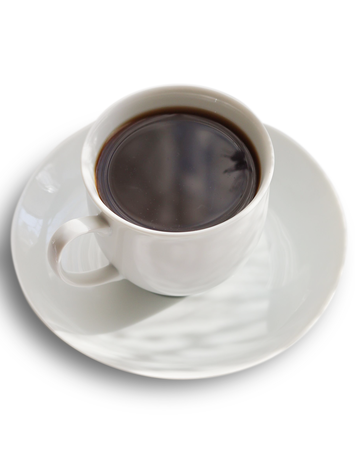 Fotografia przedstawiająca czarną kawę w białej filiżance. Widok z góry.