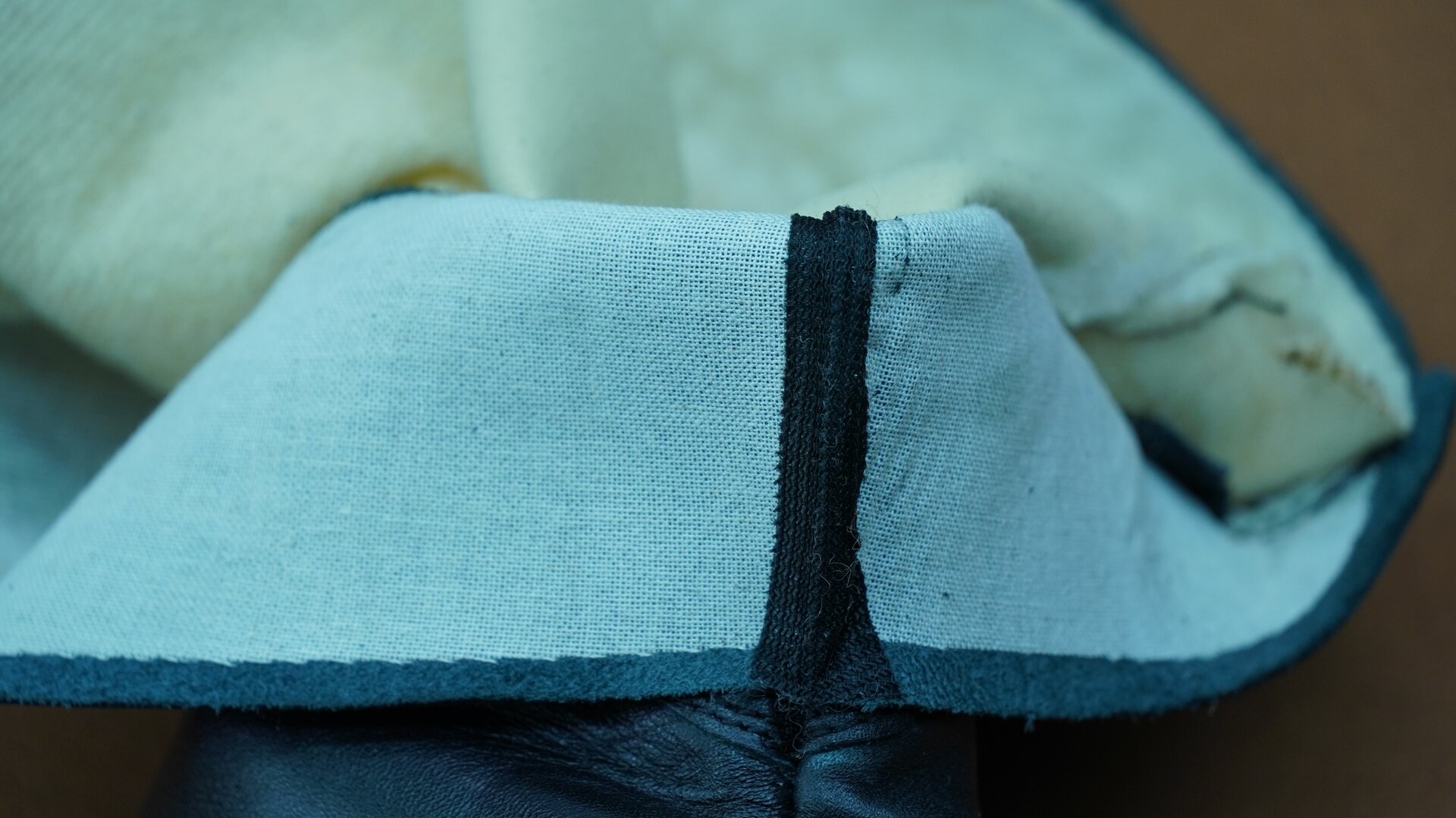 Zdjęcie przedstawia kawałek spodniej części cholewki zszytej szwem z naklejoną taśmą. Nagranie tożsame z treścią.