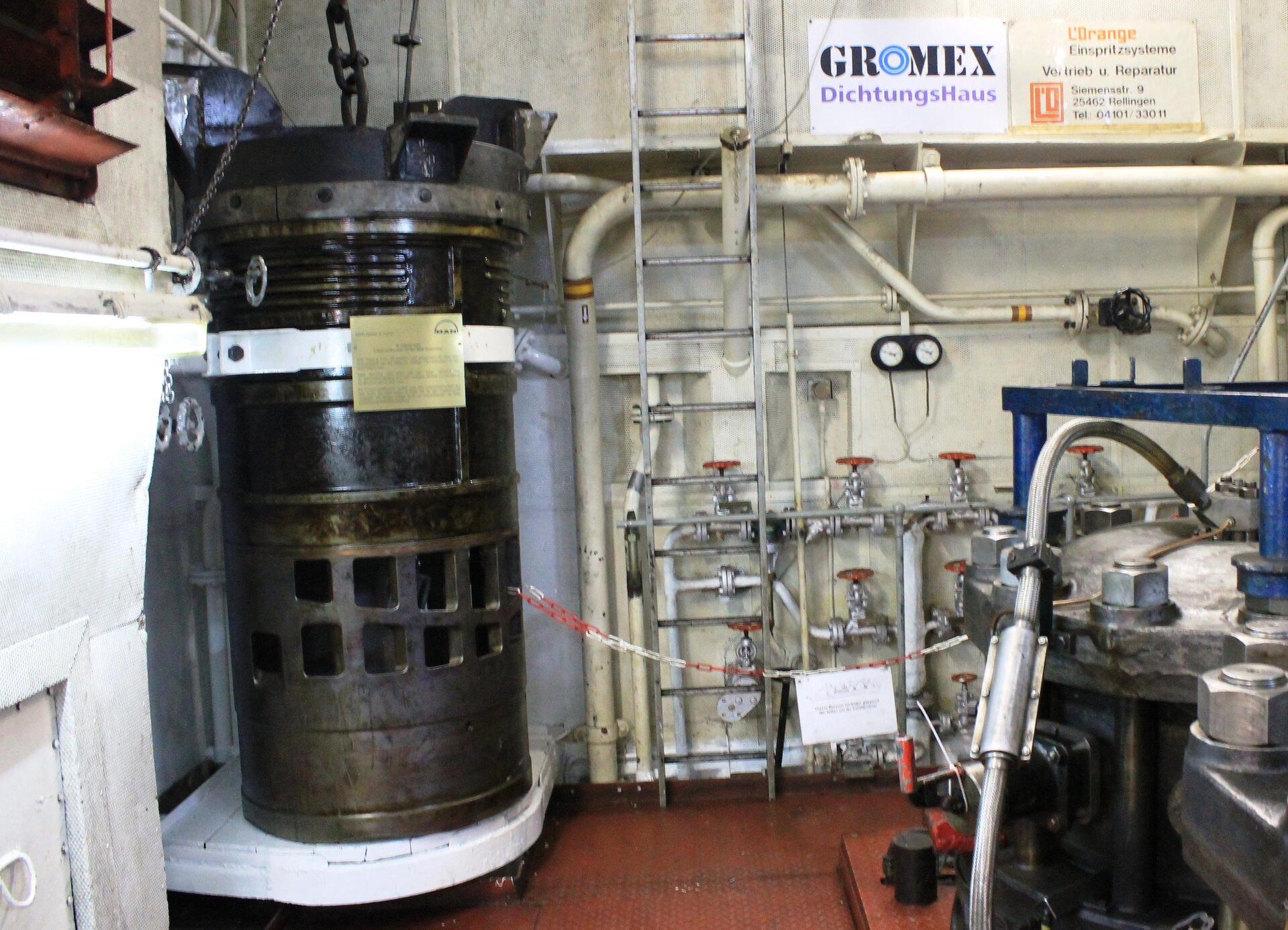 Zdjęcie przedstawia tuleję cylindrową statkowego silnika dwusuwowego. Jest to wysoki element w kształcie walca.