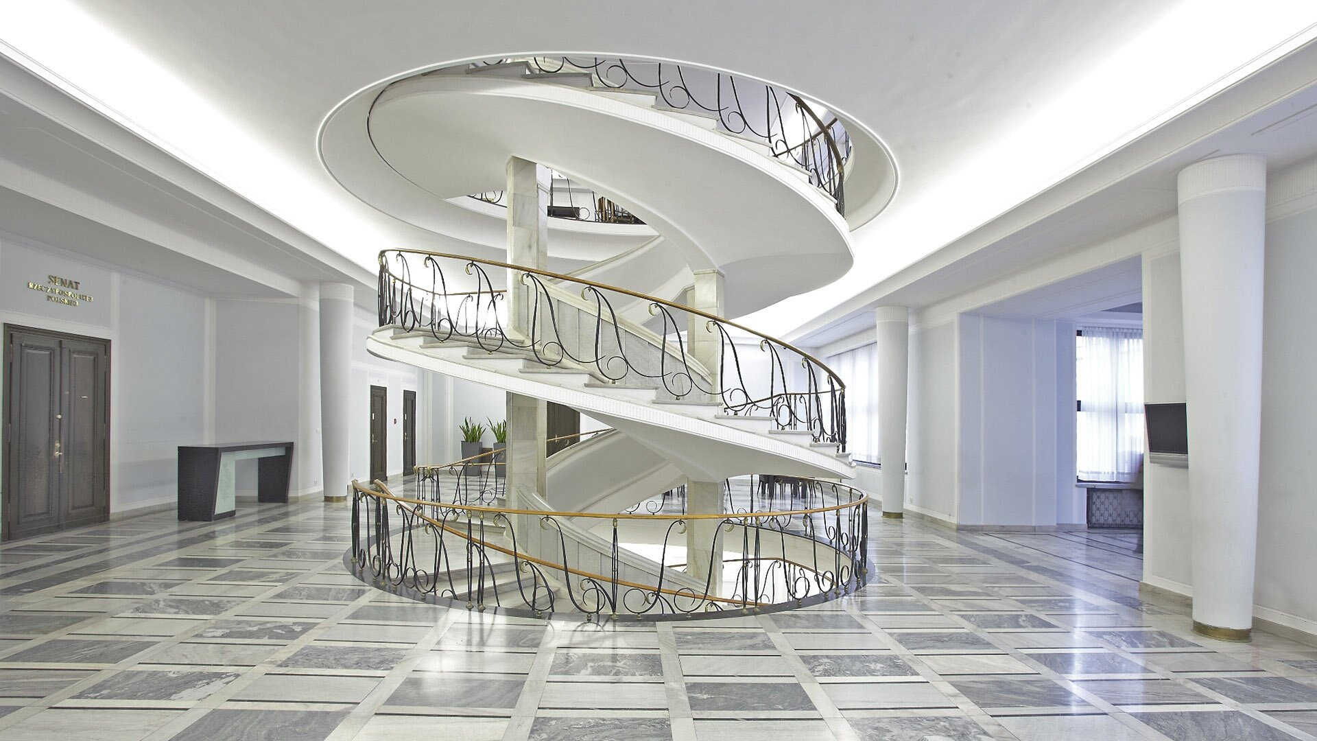 Fotografia przedstawiająca owalną otwartą klatkę schodową i korytarz w Senacie Rzeczypospolitej Polskiej.