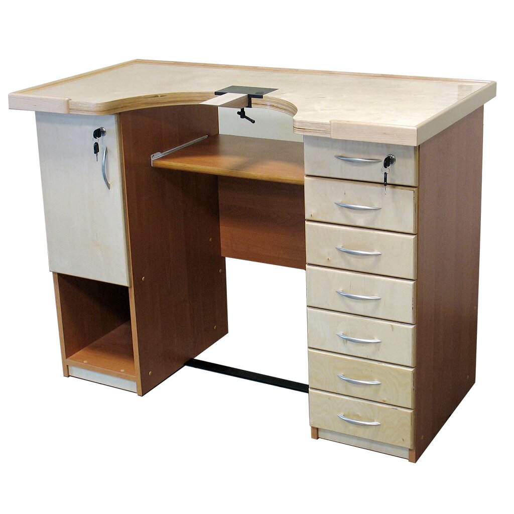 Zdjęcie przedstawia stół. Jego blat jest prostokątny z półokrągłym wycięciem na froncie. Pośrodku wycięcia znajduje się przymocowany niewielkim zaciskiem niewielki klin, wąską częścią skierowany do przodu. Po lewej stronie stołu znajduje się szafka z drzwiczkami zamykanymi na zamek, a pod nią otwarta półka. Po prawej stronie znajduje się pionowy rząd siedmiu szuflad. Górna szuflada zamykana jest na zamek. Pośrodku stołu, pod blatem znajduje się niewielka, wysuwana na prowadnicach półka. U dołu znajduje się wąska poprzeczka wzmacniająca konstrukcję.