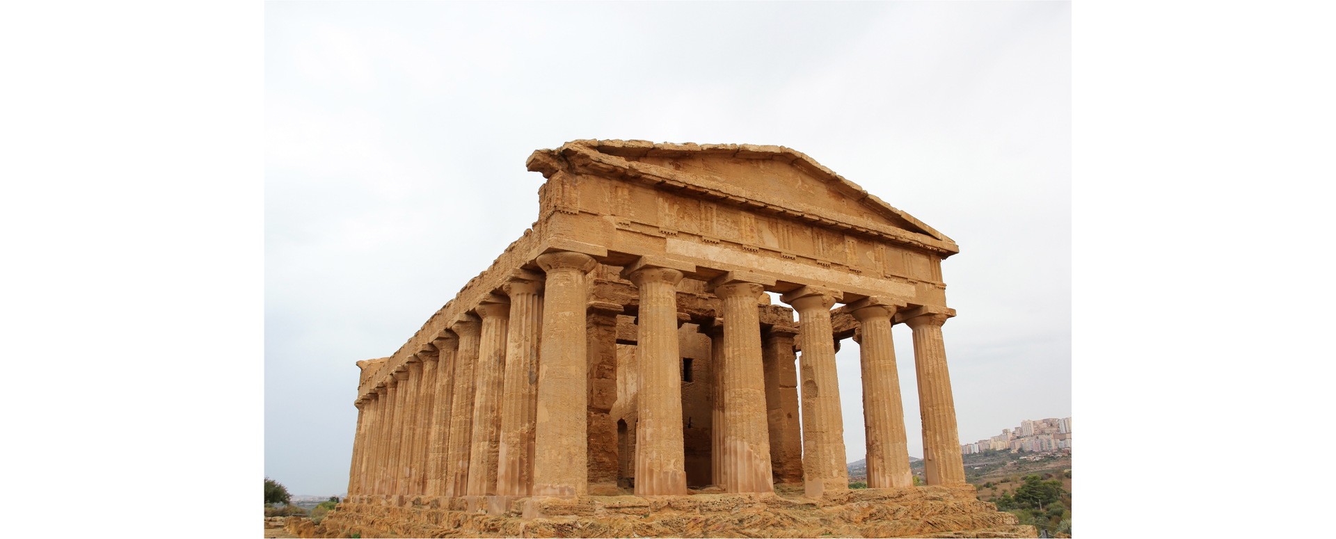 Zdjęcie przedstawia budynek Świątyni Zgody w Agrigento, mieście na południu Sycylii. Budynek wsparty jest na wielu potężnych kolumnach.