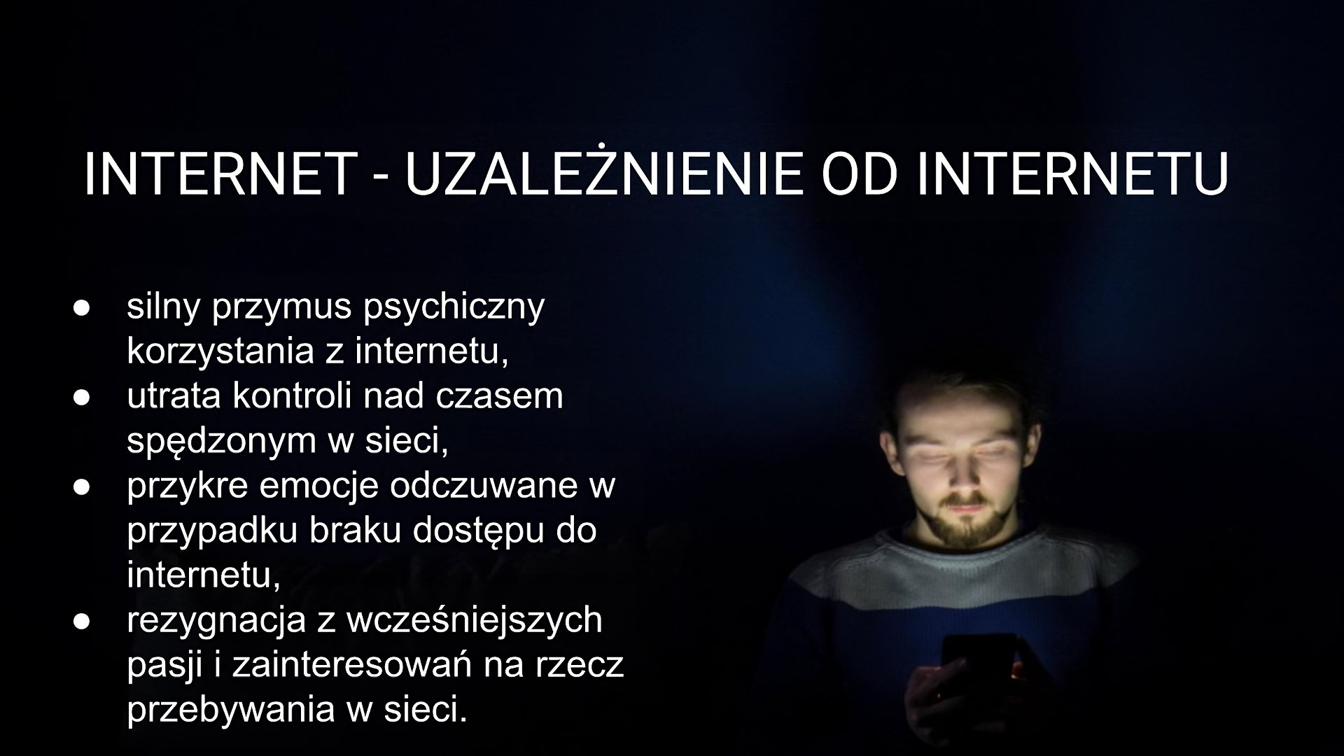 Czarny slajd zatytułowany: „Internet - uzależnienie od internetu”. Poniżej tekst: „silny przymus psychiczny korzystania z internetu, utrata kontroli nad czasem spędzonym w sieci, przykre emocje odczuwane w przypadku braku dostępu do internetu, rezygnacja z wcześniejszych pasji i zainteresowań na rzecz przebywania w sieci”. Na slajdzie umieszczono zdjęcie w czarnej kolorystyce przedstawiające mężczyznę patrzącego na trzymany w rękach telefon komórkowy.