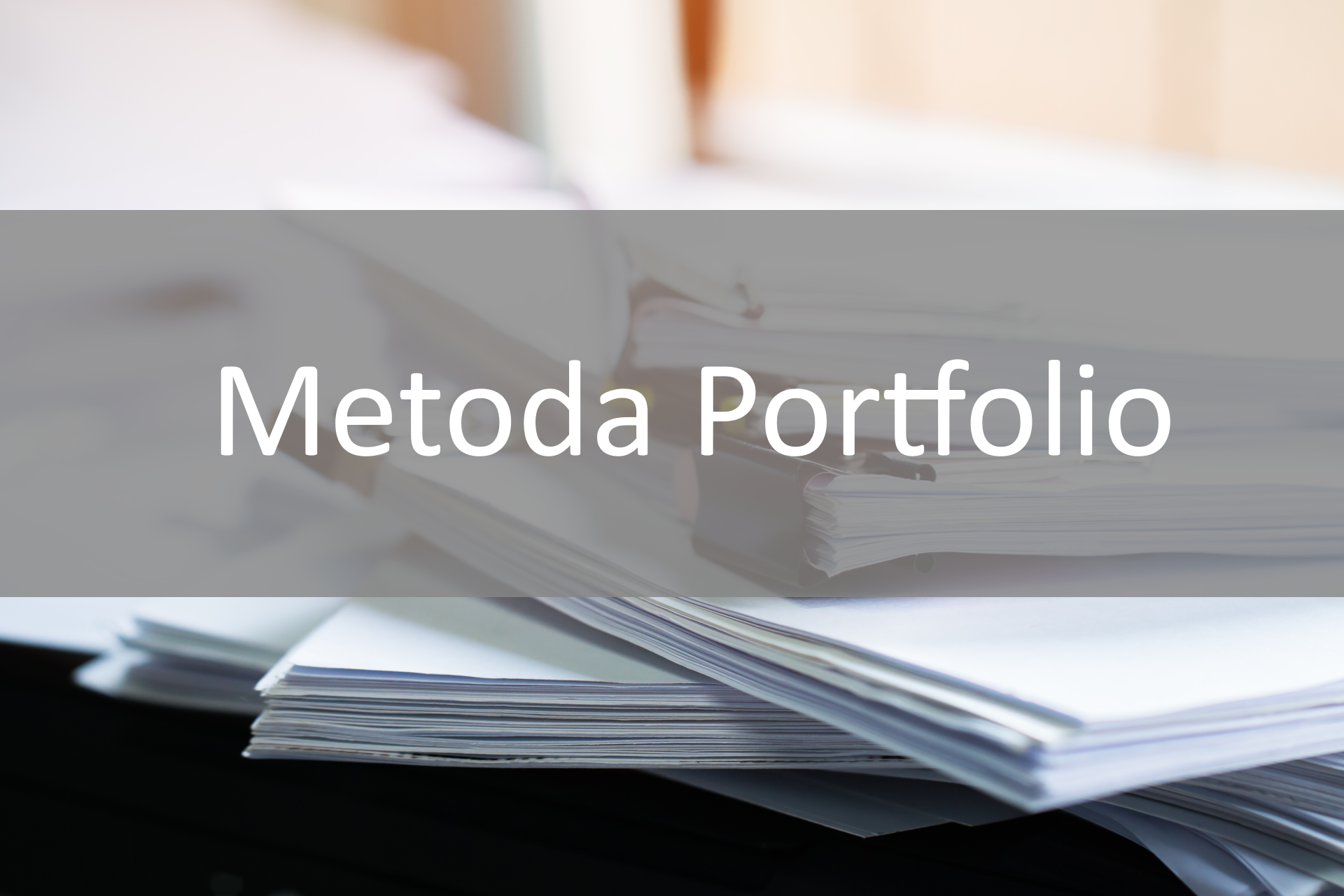 Ilustracja przedstawia biały napis na szarym tle; Metoda Portfolio. Pod tekstem widoczne są spięte arkusze papieru leżące na stole. 