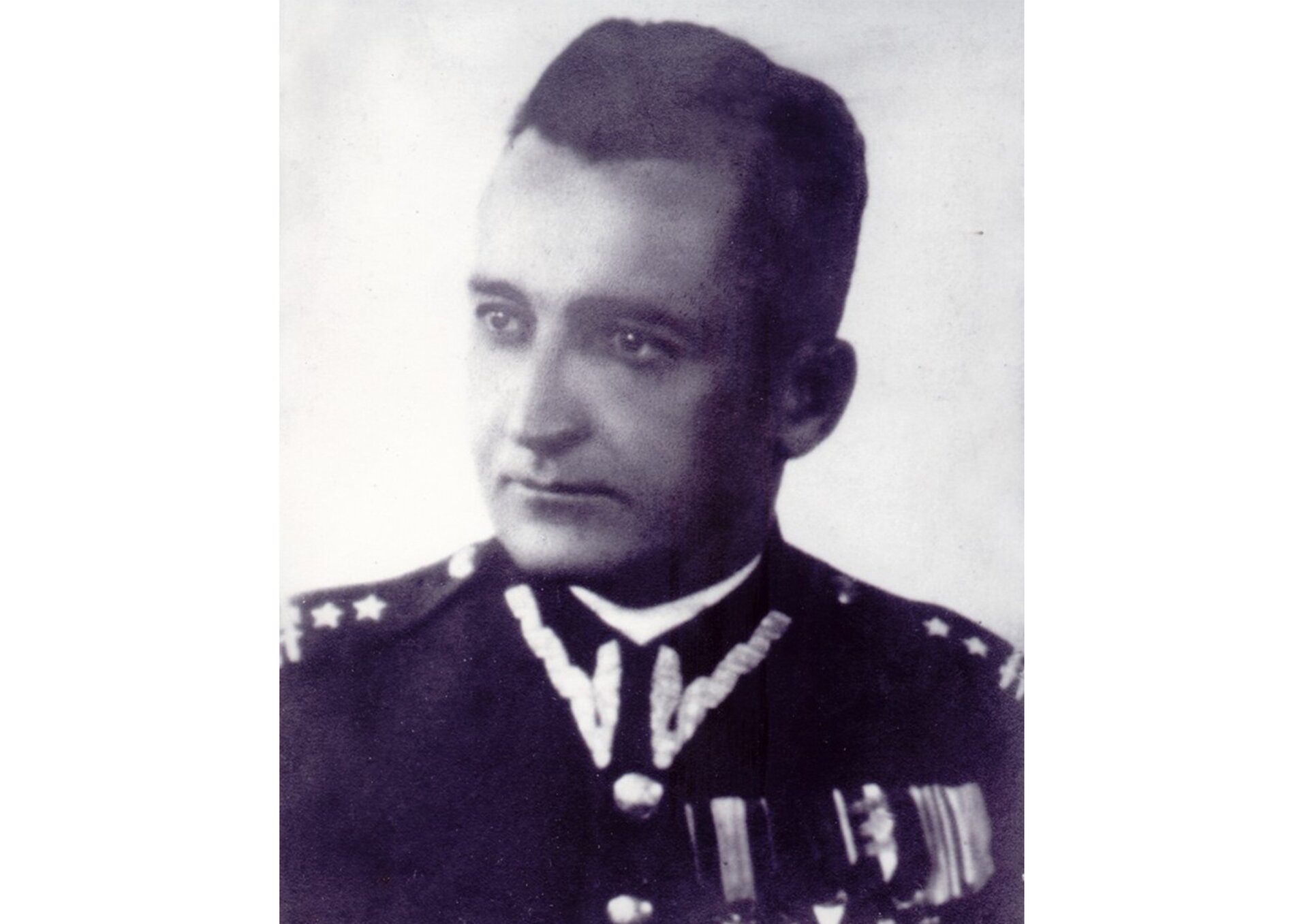 Czarno-biała fotografia portretowa generała Augusta Emila Fieldorfa w mundurze. Mężczyzna o pociągłej twarzy; głowa zwrócona w lewo; włosy krótkie, ciemne, zaczesane do góry. 