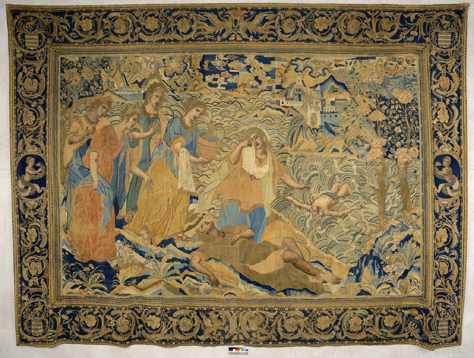 Ilustracja przedstawia wyhaftowany obraz zatytułowany „Śmierć Polydora” nieznanego autora. Haft w większości wykonany jest złotą nitką na granatowym tle. Przedstawia siedem postaci. Na środku leży postać w beżowej szacie. Nad nią nachyla się pięć postaci w żółto- pomarańczowo niebieskich szatach. Na drugim planie z prawej strony leży półnaga postać. W tle są drzewa i budynki. Dookoła obrazu biegnie ozdobna ramka. 