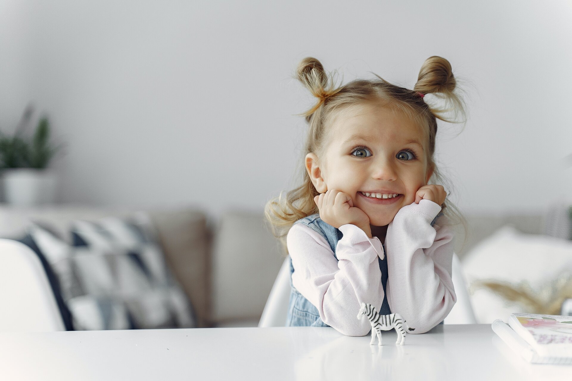 Ilustracja przedstawia uśmiechniętą dziewczynkę.