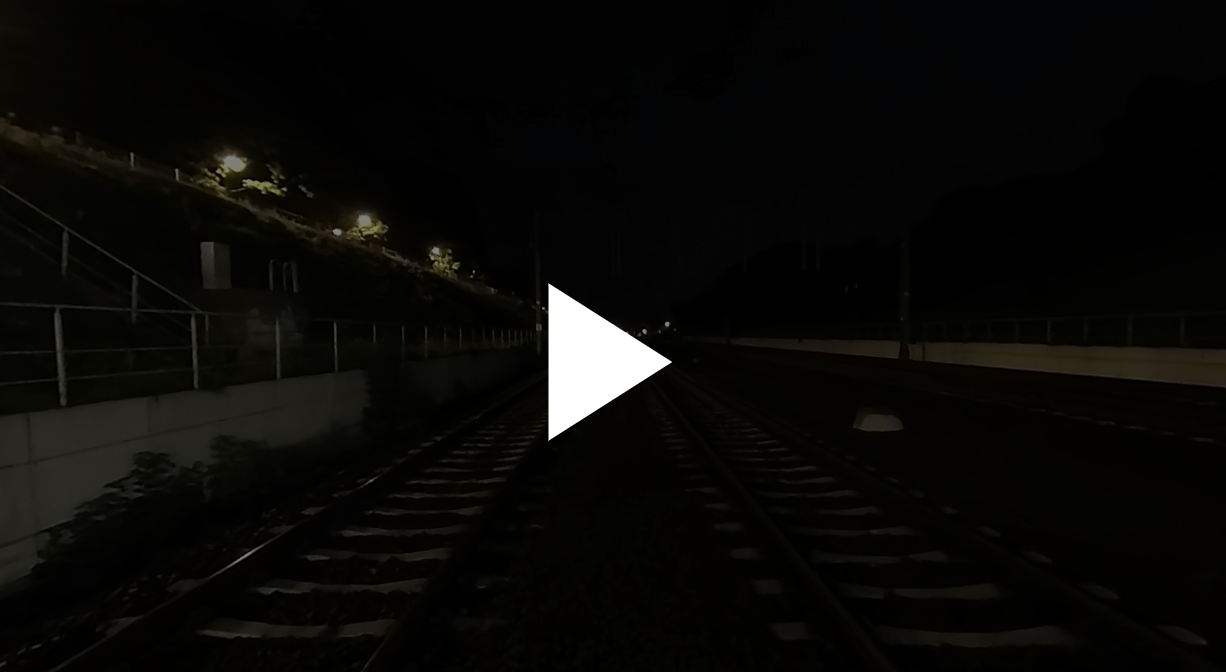 Przykładowy ekran startowy wycieczki. W tle widoczne jest ciemne zdjęcie. Na pierwszym planie na środku zdjęcia znajduje się biały trójkąt równoramienny z wierzchołkiem skierowanym w prawo.