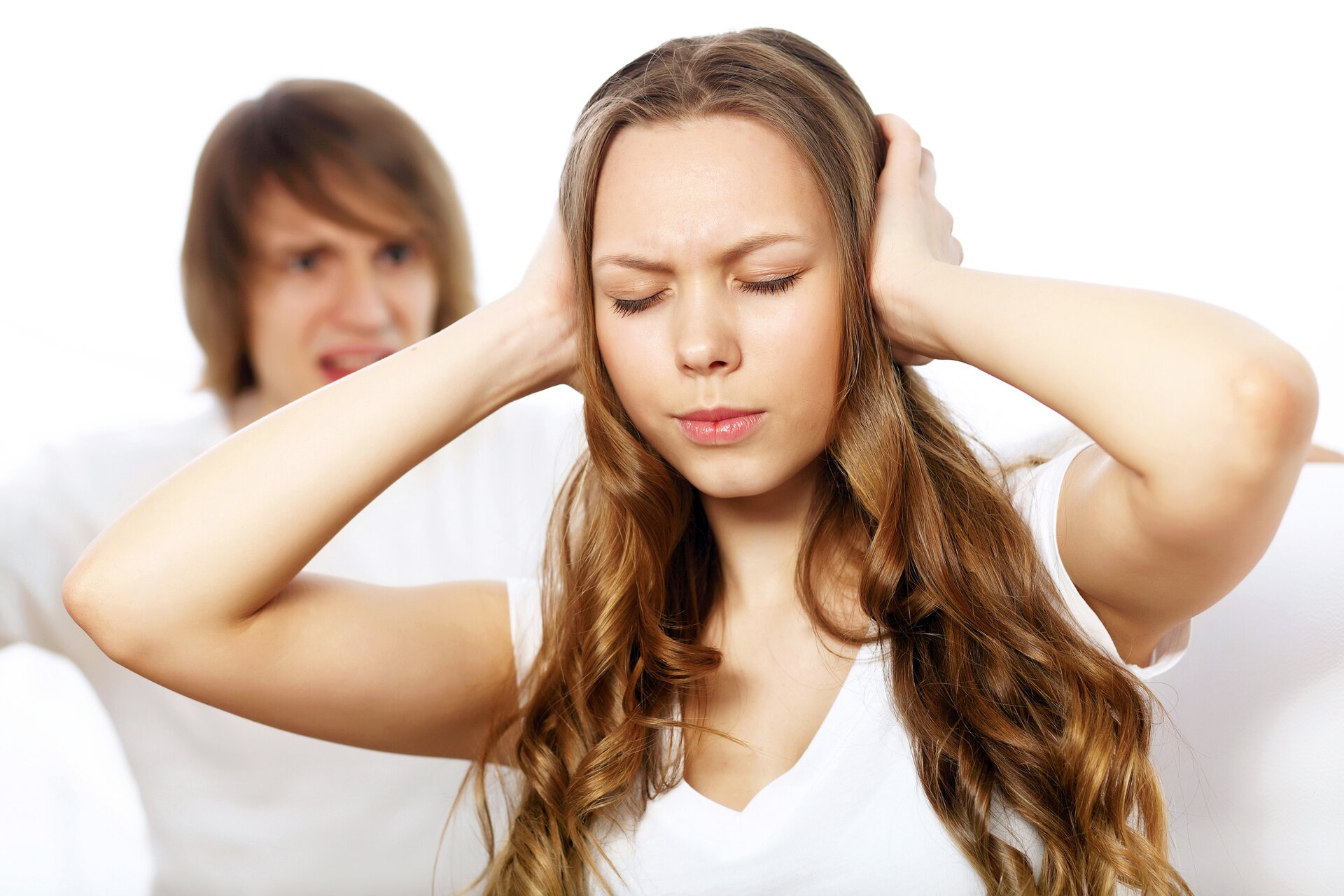 Zdjęcie - kłótnia. Chłopak krzyczy, jest zdenerwowany. Ubrany w białą koszulkę. Ma dłuższe włosy. Natomiast dziewczyna zasłania sobie uszy rękoma. Ma zamknięte oczy, ściśnięte usta, ściągnięte brwi. Fryzura dziewczyny to długie i rozpuszczone włosy. Ubrana w białą koszulkę.
