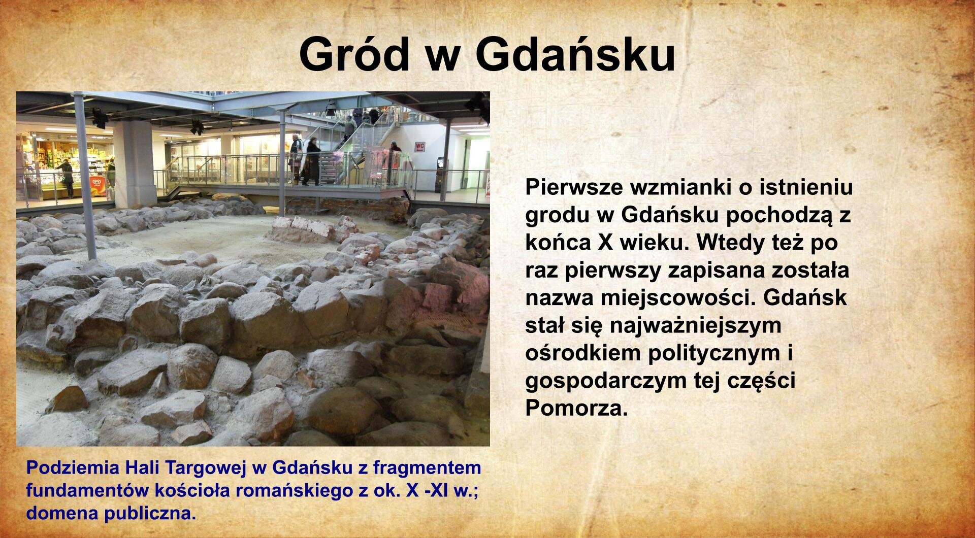 Na jasnobrązowym tle umieszczony został  tytuł. Slajd zatytułowany jest: Gród. Napis został wykonany w kolorze czarnym. Po lewej stronie znajduje się napis wykonany w kolorze czerwonym: Pierwsze wzmianki o istnieniu grodu w Gdańsku pochodzą z końca X wieku. Wtedy też po raz pierwszy zapisana została nazwa miejscowości. Gdańsk stał się najważniejszym ośrodkiem politycznym i gospodarczym tej części Pomorza. Po prawej stronie znajduje się ilustracja. Przedstawia ona fragmenty murów pochodzące z XII wieku. Ilustracja podpisana jest: Podziemia Hali Targowej w Gdańsku z zabytkami romańskimi z XII wieku. Napis wykonany został w kolorze czarnym. 