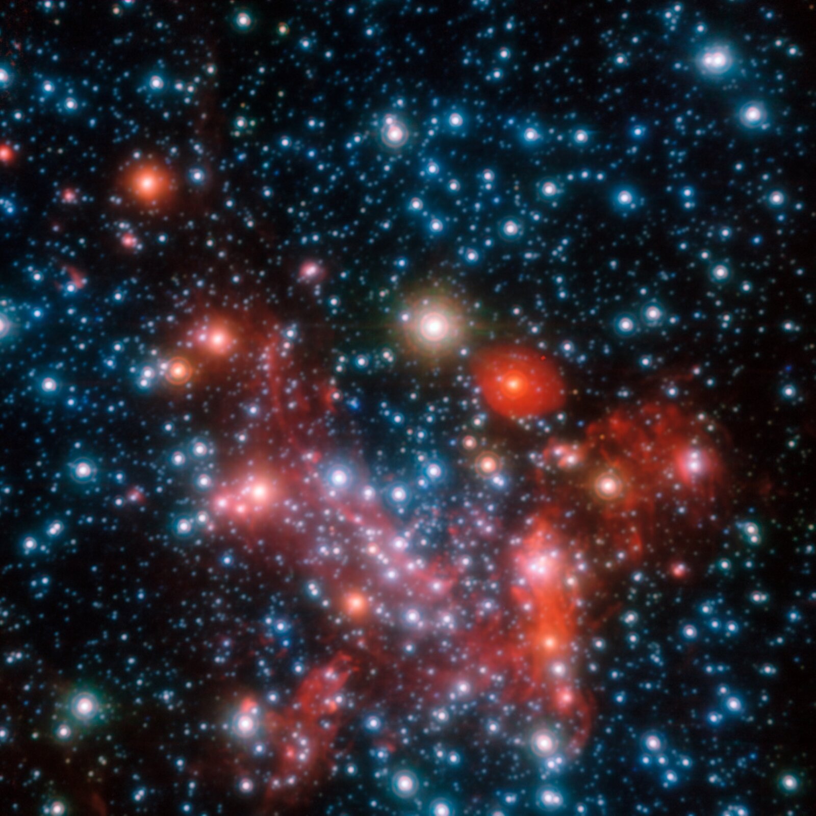 Rys. 4. Zdjęcie z teleskopu pokazuje gwiazdy w centrum Dogi Mlecznej. Ciemne tło gęsto usiane jest jasnymi świetlistymi punktami. W centrum znajduje się kilkanaście skupionych świetlistych, nieco większych, kolistych obiektów w kolorach czerwonym, białym i niebieskim.