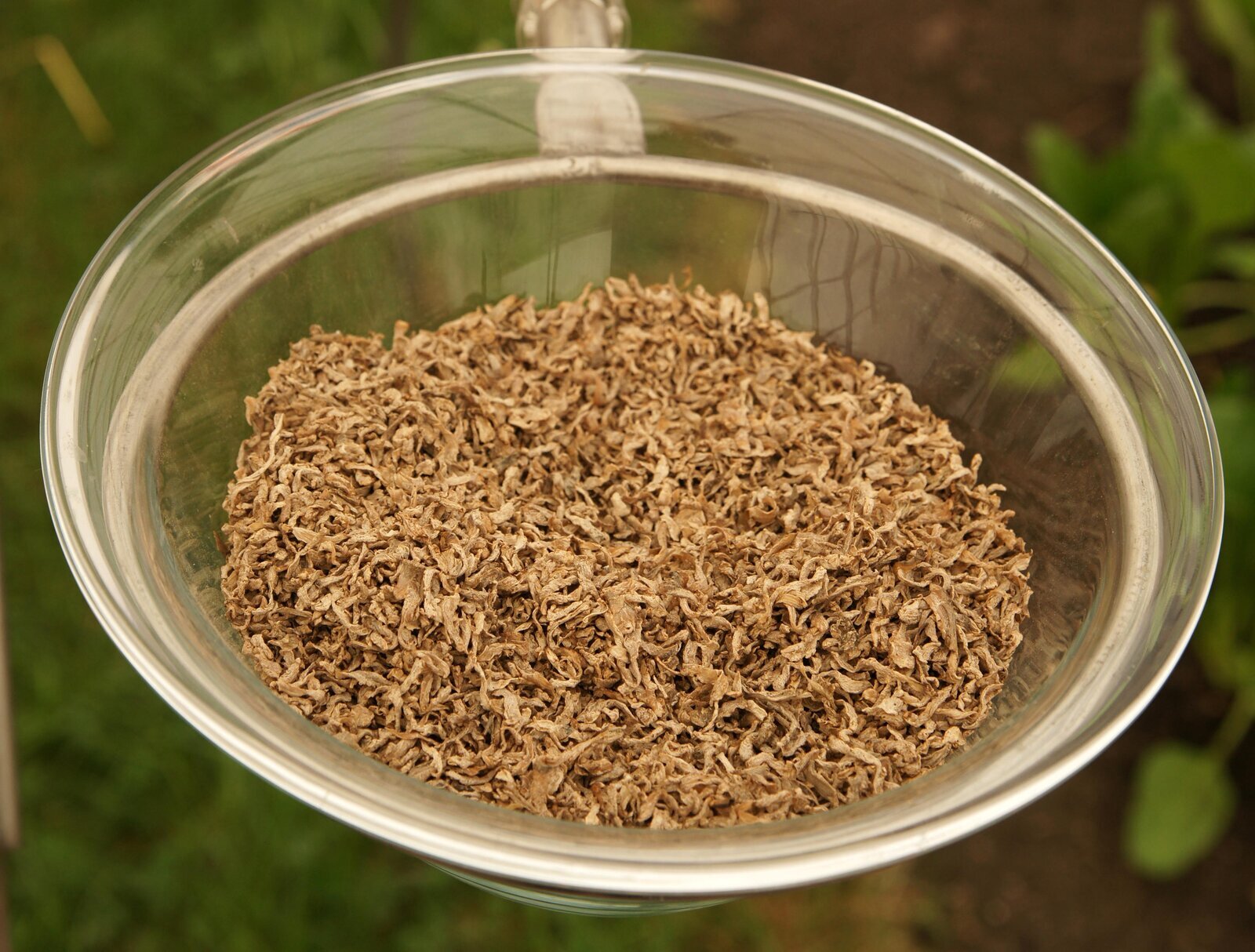 Zdjęcie przedstawia miskę, w której znajdują się wysłodki. Są to drobne, wysuszone fragmenty roślin. Mają jasnobrązową barwę.