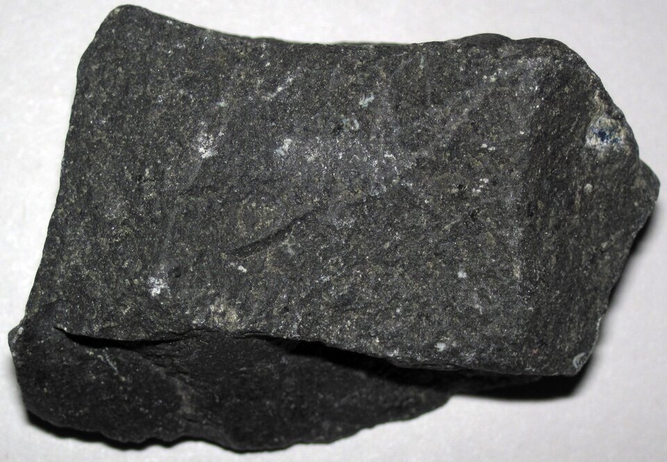 Zdjęcie przedstawia bazalt. Ma on gładką powierzchnię zbudowaną z kryształów. Posiada czarną barwę.