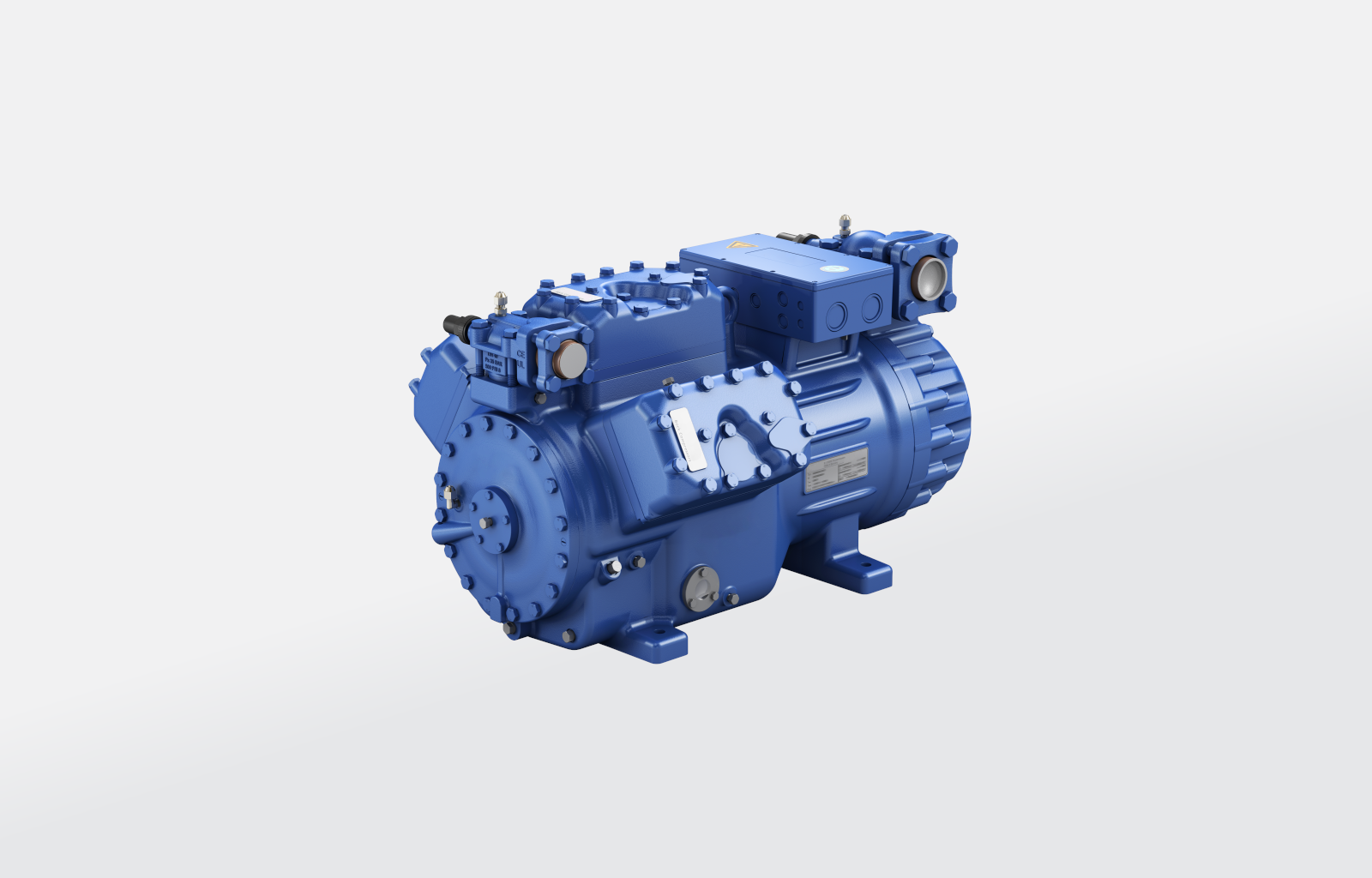 Grafika przedstawia model sprężarki hermetycznej. Jest to trójwymiarowa konstrukcja. Korpus urządzenia ma złożony kształt. W części przedniej widoczna jest tarcza sprężarki. Wcięcia i załamania na korpusie stanowią miejsca połączeń między poszczególnymi elementami konstrukcyjnymi. Są to wypukłości o kształcie prostopadłościanów i walców. Na powierzchni widoczne są złącza, otwory i tabliczka znamionowa.