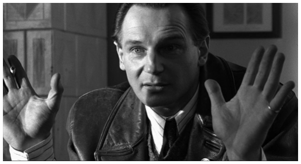 Zdjęcie przedstawia Schindlera. Mężczyzna ma uniesione do góry ręce.