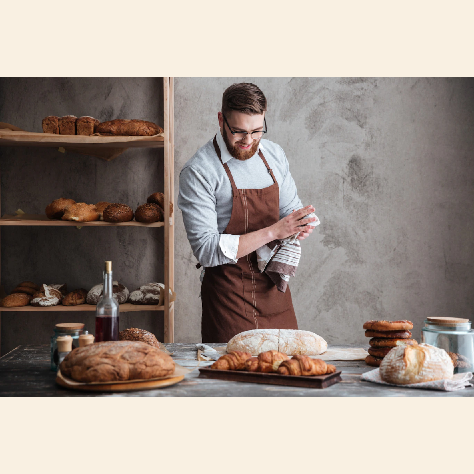 Ilustracja przedstawia piekarza, który wyciera dłonie i przygląda się radośnie różnym wypiekom rozłożonym przed nim na stole.