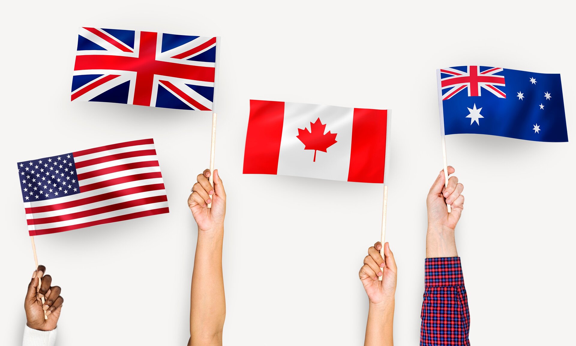 Ilustracja przedstawia cztery podniesione ręce, trzymające chorągiewki z flagami państw anglojęzycznych. Pierwsza jest flaga Stanów Zjednoczonych, składająca się z poziomych pasków białych i czerwonych, a w jej lewym górnym rogu znajduje się niebieski prostokąt z rzędami białych gwiazdek. Druga jest flaga Wielkiej Brytanii, na której na niebieskim tle łączą się czerwony znak iks i czerwony krzyż. Kolor czerwony i niebieski oddzielone są kolorem białym. Trzecia jest flaga Kanady, składająca się z trzech pionowych pasów: czerwonego, białego i czerwonego. Na szerszym, białym pasie widnieje czerwony liść klonu. Czwarta jest flaga Australii. Jest to niebieska flaga, w której lewym górnym rogu widzimy flagę Wielkiej Brytanii, poniżej dużą, białą, siedmioramienną gwiazdę, a po prawej stronie cztery siedmioramienne gwiazdy ułożone jak na wierzchołkach krzyża, z dodatkową, pięcioramienną gwiazdą między nimi.