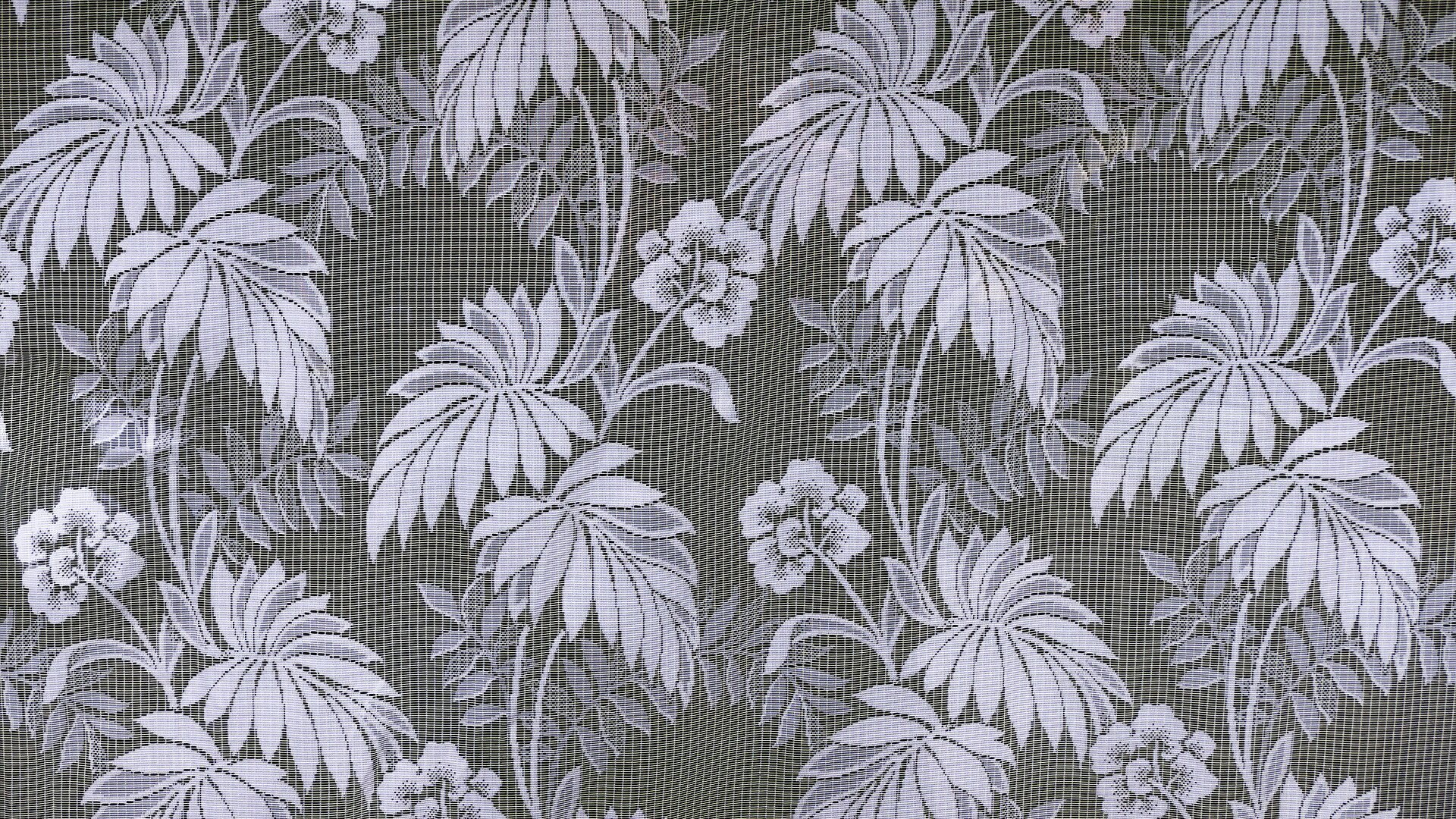 Na zdjęciu ukazano próbkę żakardu. Na ciemnym tle widoczny jest jasny, kwiatowy wzór.