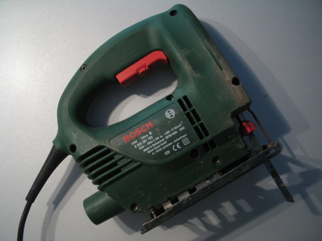 Zdjęcie przedstawia wyrzynarkę. Posiada ona uchwyt w górnej części, a w dolnej piłkowane ostrze.