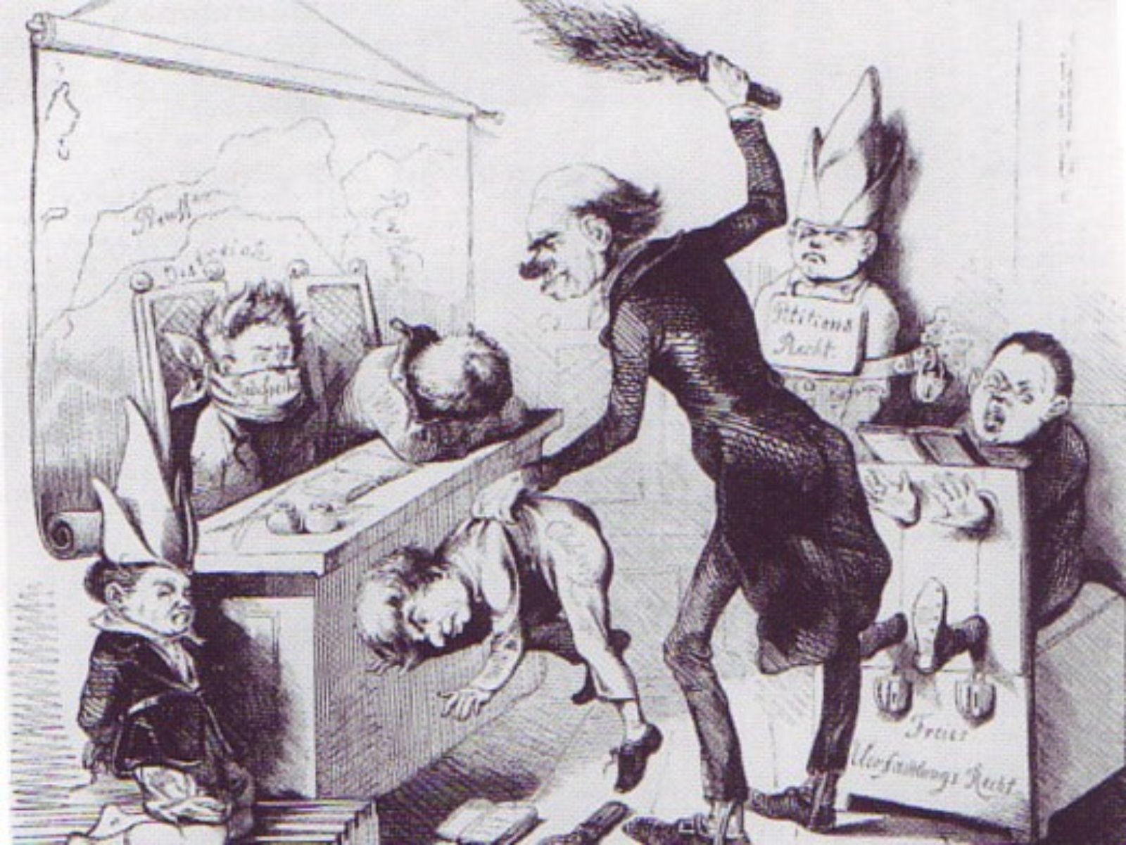 Grafika przedstawia scenkę w klasie. Pośrodku widoczna jest karykaturalnie przedstawiona postać nauczyciela, który w lewej ręce trzyma dziecko za koszulę i podnosi je do góry, a w prawej ręce, uniesionej nad głową, trzyma rózgę. Na lewo widoczna jest ławka, przy której siedzi dwie osoby – jedna ma twarz obwiązaną szmatą, a druga położoną na ławce głowę opartą na ręce. Przed ławką klęczy kolejna osoba wysokiej czapie z oślimi uszami. Po prawej stronie widoczna jest postać zakuta w dyby, a obok niej postać przykuta do ściany, z nałożoną na głowę wysoką czapką z oślimi uszami.