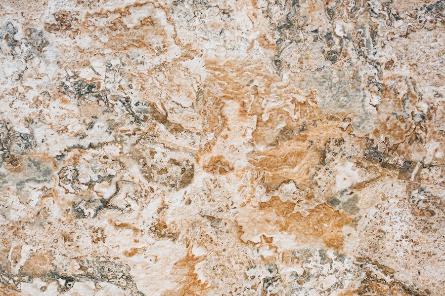 Zdjęcie przedstawia kamień o nieregularnych wzorach i barwach, o fakturze gradzinowanej.