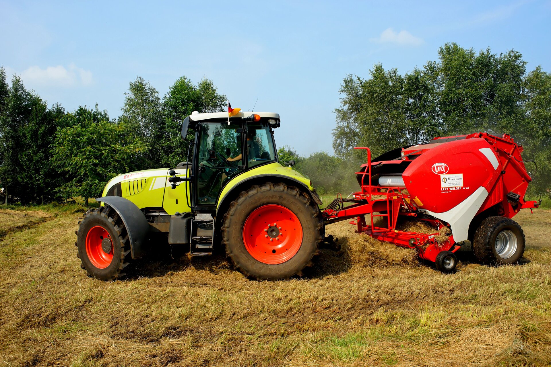 Zdjęcie drugie, podpisane nadzorowanie produkcji roślinnej. Przedstawiony jest traktor z maszyną rolniczą przymocowaną z tyłu. Maszyna wciąga skoszoną wcześniej trawę.