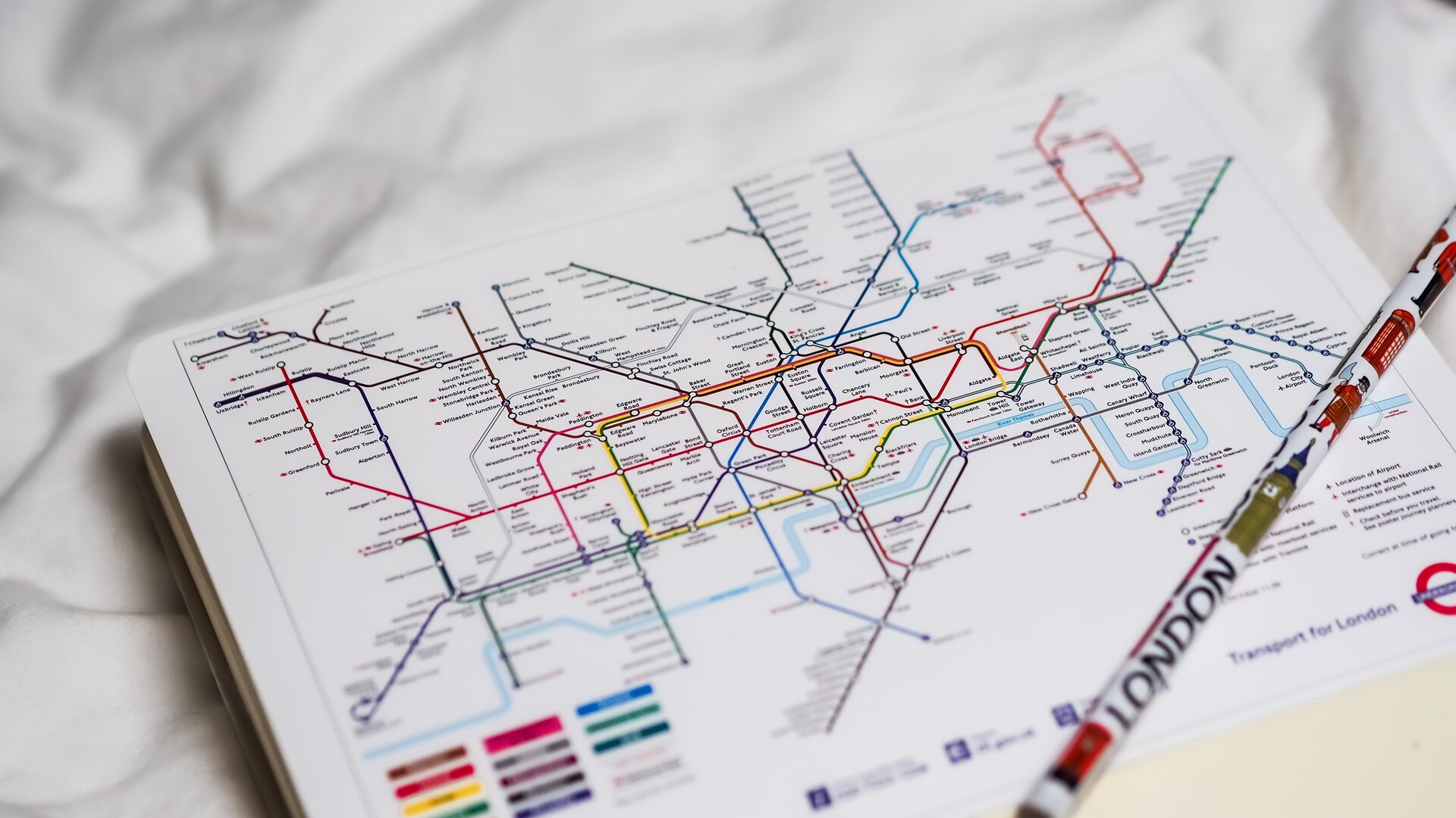 Zdjęcie przedstawia plan linii metra na którym leży ołówek z napisem LONDON.