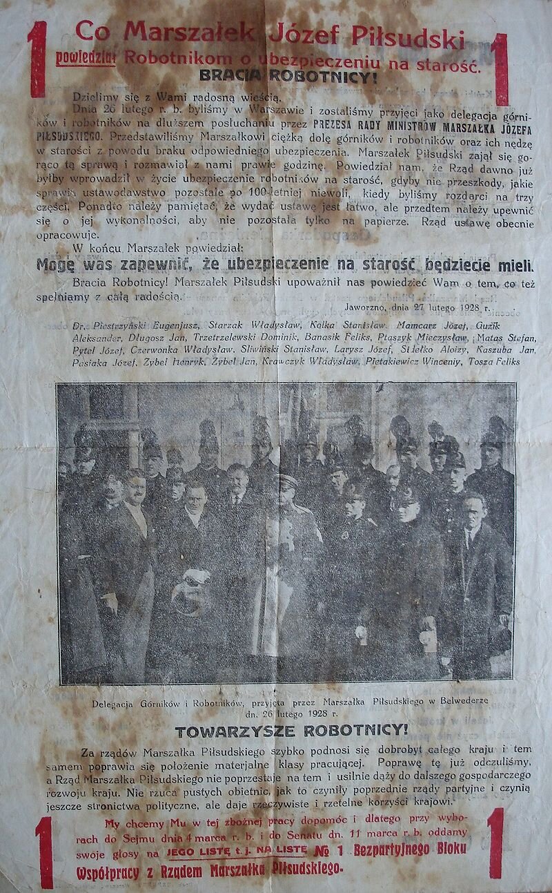  Ilustracja przedstawia ulotkę z tytułem: "Co marszałek Józef Piłsudski powiedział robotnikom o ubezpieczeniu na starość?". Poniżej tekstu znajduje się zdjęcie przedstawiające delegację Górników i Robotników przyjętą przez marszałka Piłsudskiego w Belwederze. Ubrani są w służbowe garnitury z odznakami. Na fragmencie ulotki znajduje się następujący tekst: "Bracia robotnicy! Dzielimy się z Wami radosną wieścią. Dnia 26 lutego bieżącego roku byliśmy w Warszawie i zostaliśmy przyjęci jako delegacja górników i robotników na dłuższem posłuchaniu przez PREZESA RADY MINISTRÓW MARSZAŁKA JÓZEFA PIŁSUDSKIEGO. Przedstawiliśmy Marszałkowi ciężką dolę górników i robotników oraz ich nędzę w starości z powodu braku odpowiedniego ubezpieczenia. Marszałek Piłsudski zajął się gorąco tą sprawą i rozmawiał z nami prawie godzinę. Powiedział nam, że Rząd dawno już byłby wprowadził w życie ubezpieczenie robotników na starość, gdyby nie przeszkody, jakie sprawia ustawodawstwo pozostałe po 100‑letniej niewoli, kiedy byliśmy rozdarci na trzy części. Ponadto należy pamiętać, że wydać ustawę jest łatwo, ale przedtem należy upewnić się o jej wykonalności, aby nie pozostała tylko na papierze. Rząd ustawę obecnie opracowuje. W końcu Marszałek powiedział: Mogę was zapewnić, że ubezpieczenie na starość będziecie mieli. Bracia Robotnicy! Marszałek Piłsudski upoważnił nas powiedzieć wam o tym co też spełniamy z całą radością. Jaworzno, dnia 27 lutego 1928 rok." Poniżej fotografii widoczny jest tekst: "Towarzysze robotnicy! Za rządów Marszałka Piłsudskiego szybko podnosi się dobrobyt całego kraju i tem samem poprawia się położenie materialne klasy pracującej. Poprawę tę już odczuliśmy, a Rząd Marszałka Piłsudskiego nie poprzestaje na tem i usilnie dąży do dalszego gospodarczego rozwoju kraju. Nie rzuca pustych obietnic, jak to czyniły poprzednie rządy partyjnie i czynią jeszcze stronnictwa polityczne, ale daje rzeczywiste i rzetelne korzyści krajowi. My chcemy mu w tej zbożnej pracy dopomóc i dlatego przy wyborach do Sejmu dnia 4 marca 1928 roku i do Senatu 11 marca 1928 roku oddamy swoje głosy na jego listę numer 1 bezpartyjnego bloku współpracy Marszałka Piłsudskiego."