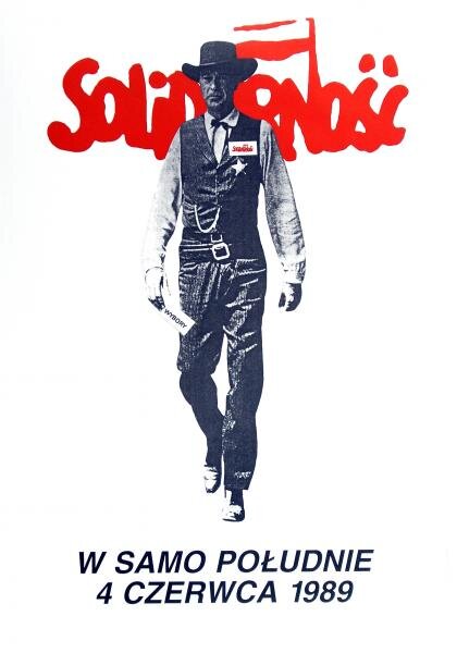 Plakat "Solidarności". Na plakacie jest idący mężczyzna w stroju kowbojskim z umieszczoną na piersi plakietką Solidarność. Za jego plecami widnieje czerwony napis Solidarność z flagą Polski. Na dole plakatu napis: W samo południe 4 czerwca 1989.