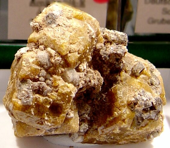 Na zdjęciu znajduje się żółty minerał. Tworzą go kryształy tabliczkowe. 